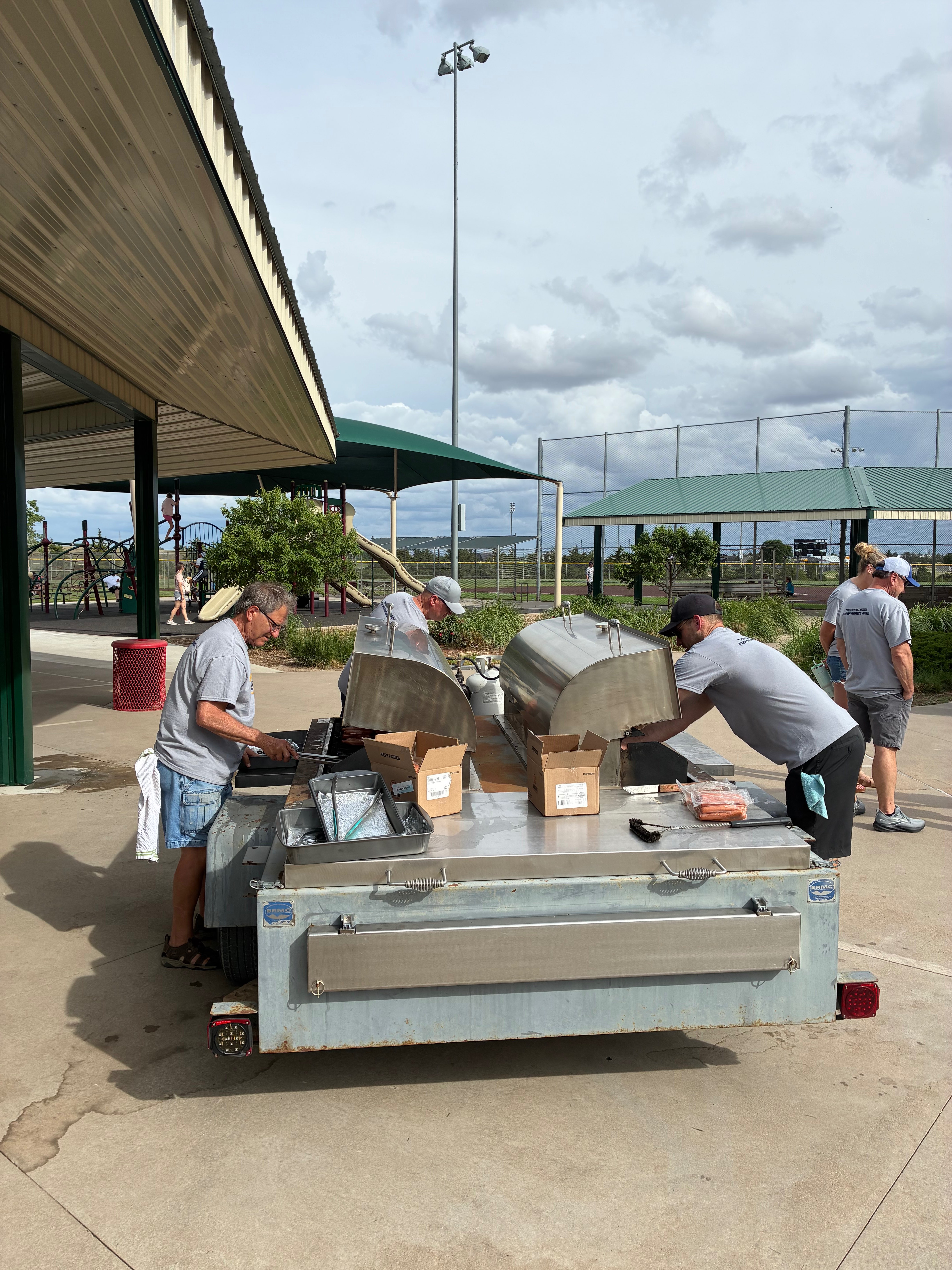 The recreation center had two grills going with three cooks ,including incoming Hays Rec director Matt Cook, right. Photo by Alin Hett/Hays Post. 