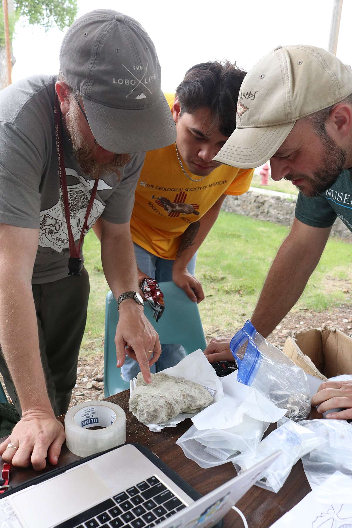 Jason Moore from the University of New Mexico, left, and Ashley Poust with the UNL State Museum, right, along with a third researcher inspect a fossil found at Toadstool Geologic Park during a two-week dig this spring. Photo by Kerri Rempp/Discover Northwest Nebraska