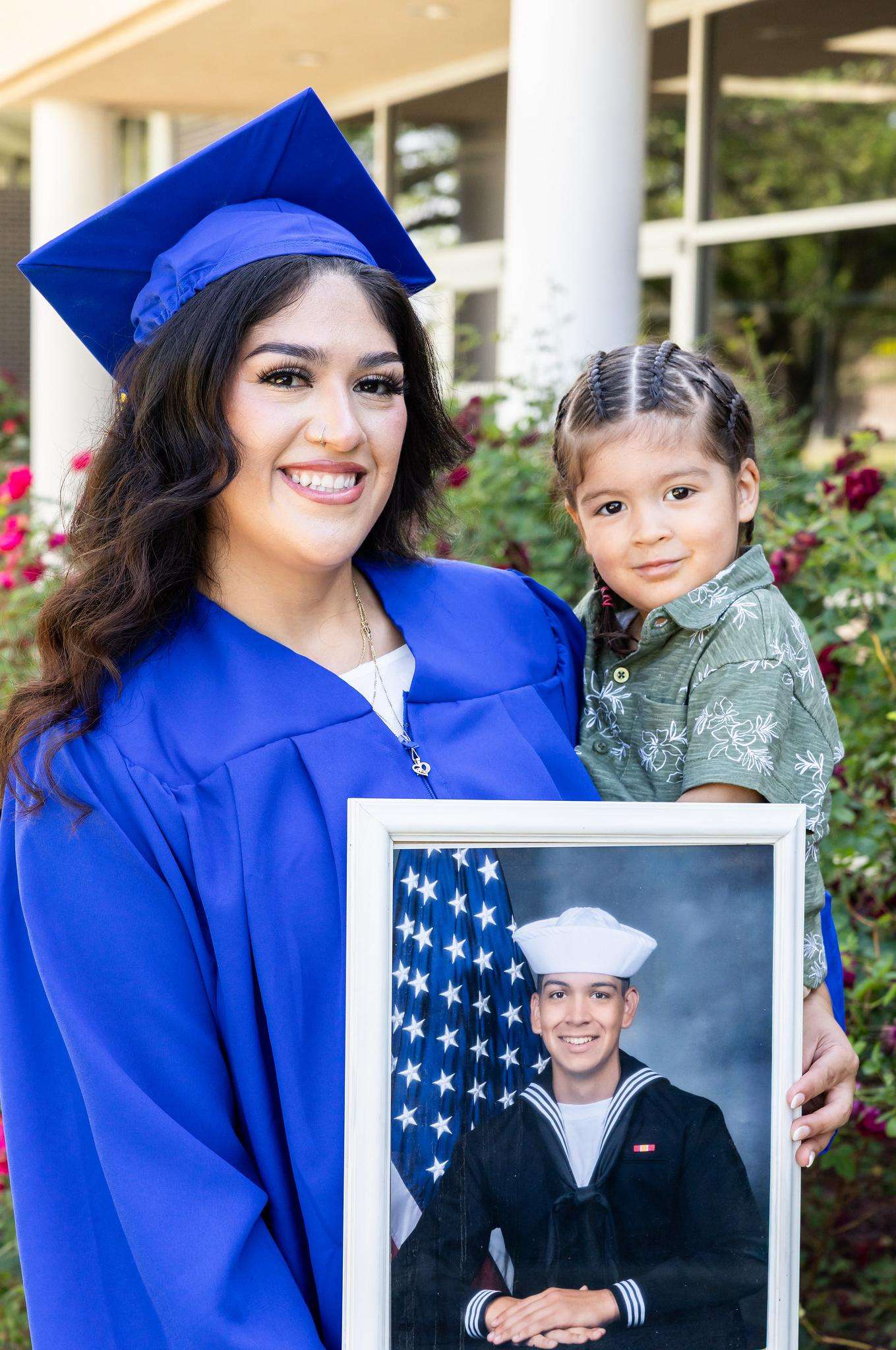 Barton Online Graduate Enedina "Nina" Espinoza and her son pose with a photo of her husband before the Barton Commencement Ceremony in May.