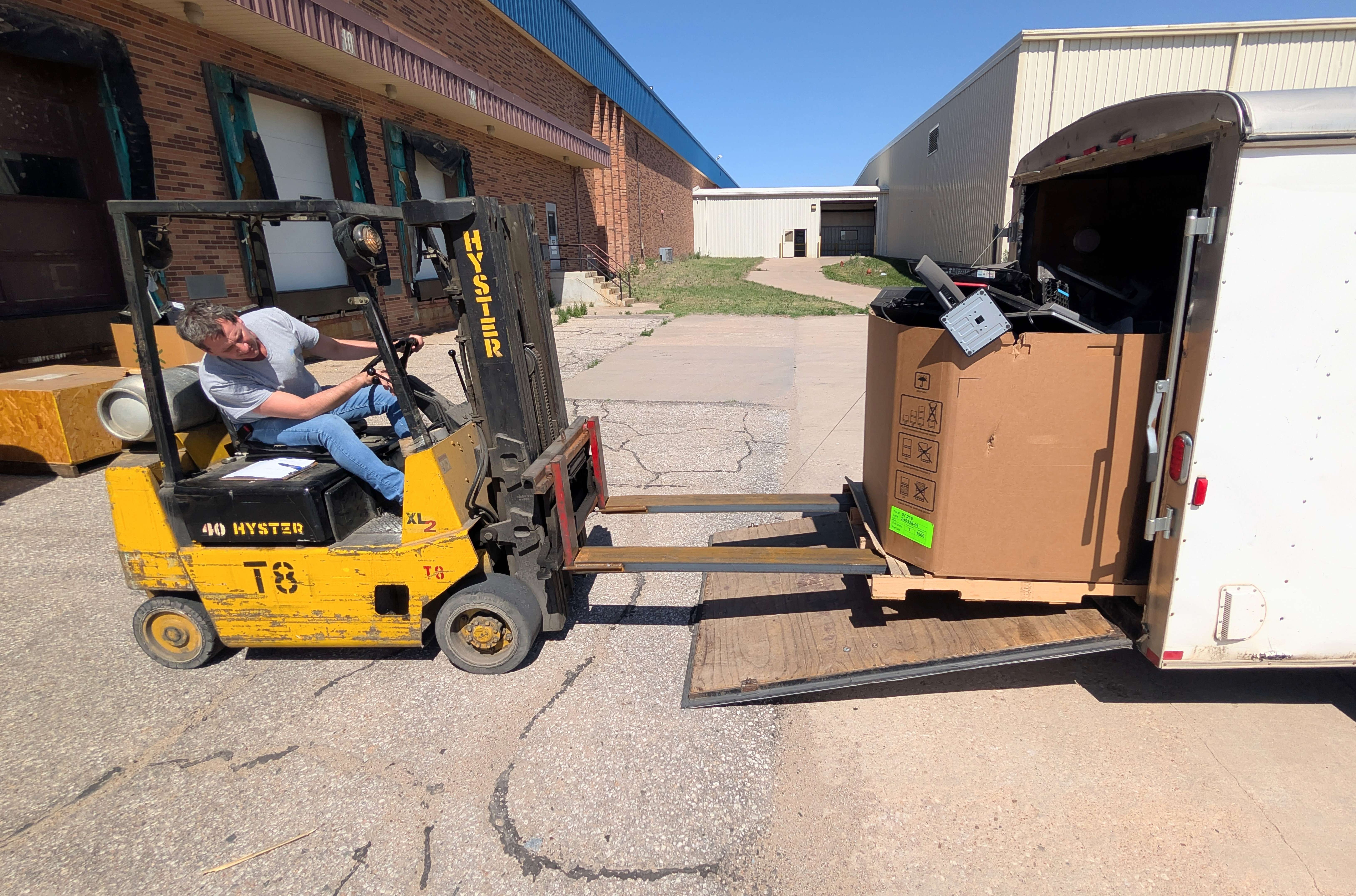 Fuller Industries Shipping and Receiving Manager Dean Henning loads crates filled with damaged electronic equipment into a trailer from Rosewood Services’ ECycle at Fuller Monday afternoon.