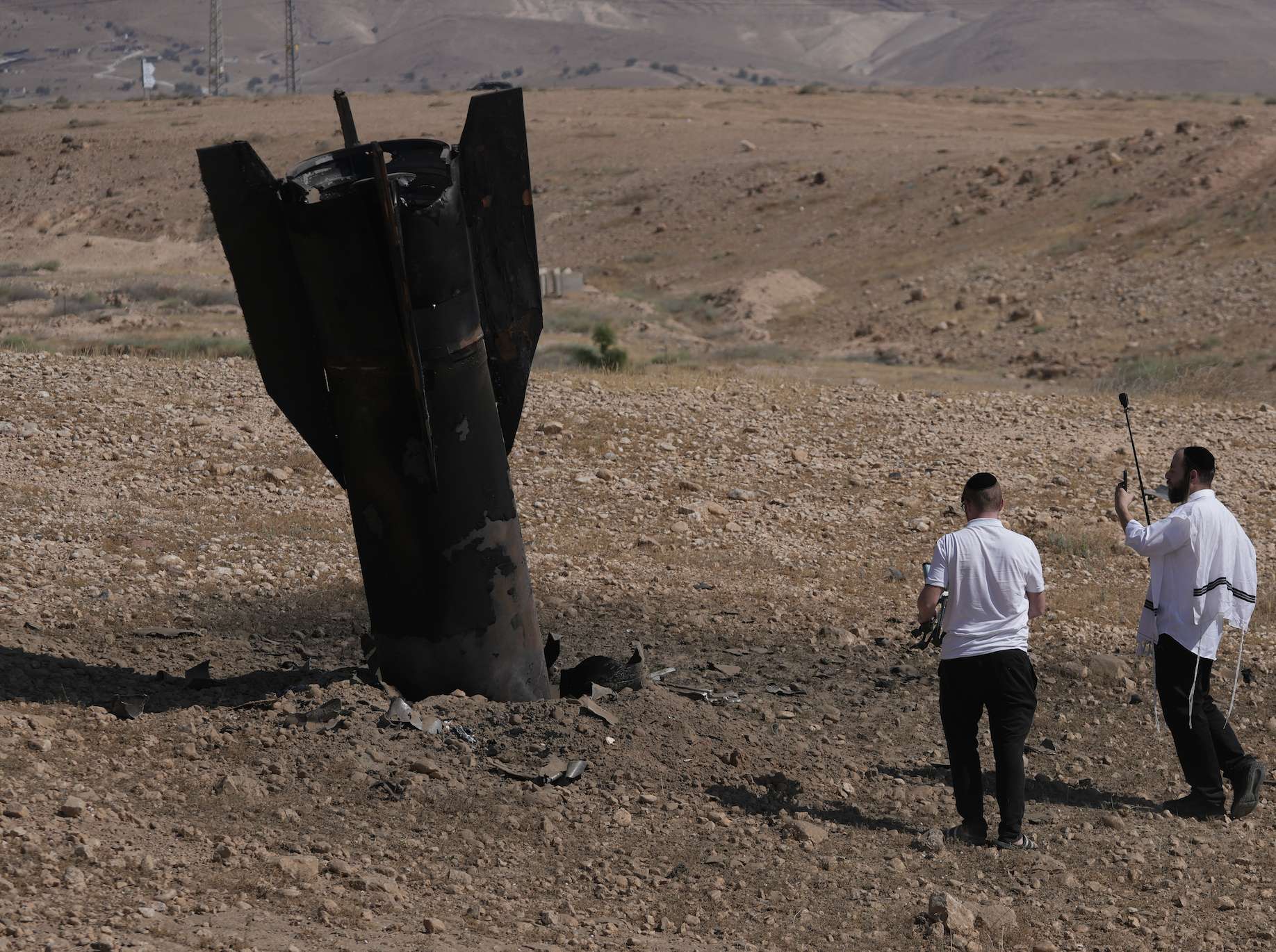 People inspect the wreckage of an Iranian missile that landed near the West Bank city of Jericho Monday, June 8, 2026. (AP Photo/Mahmoud Illean)