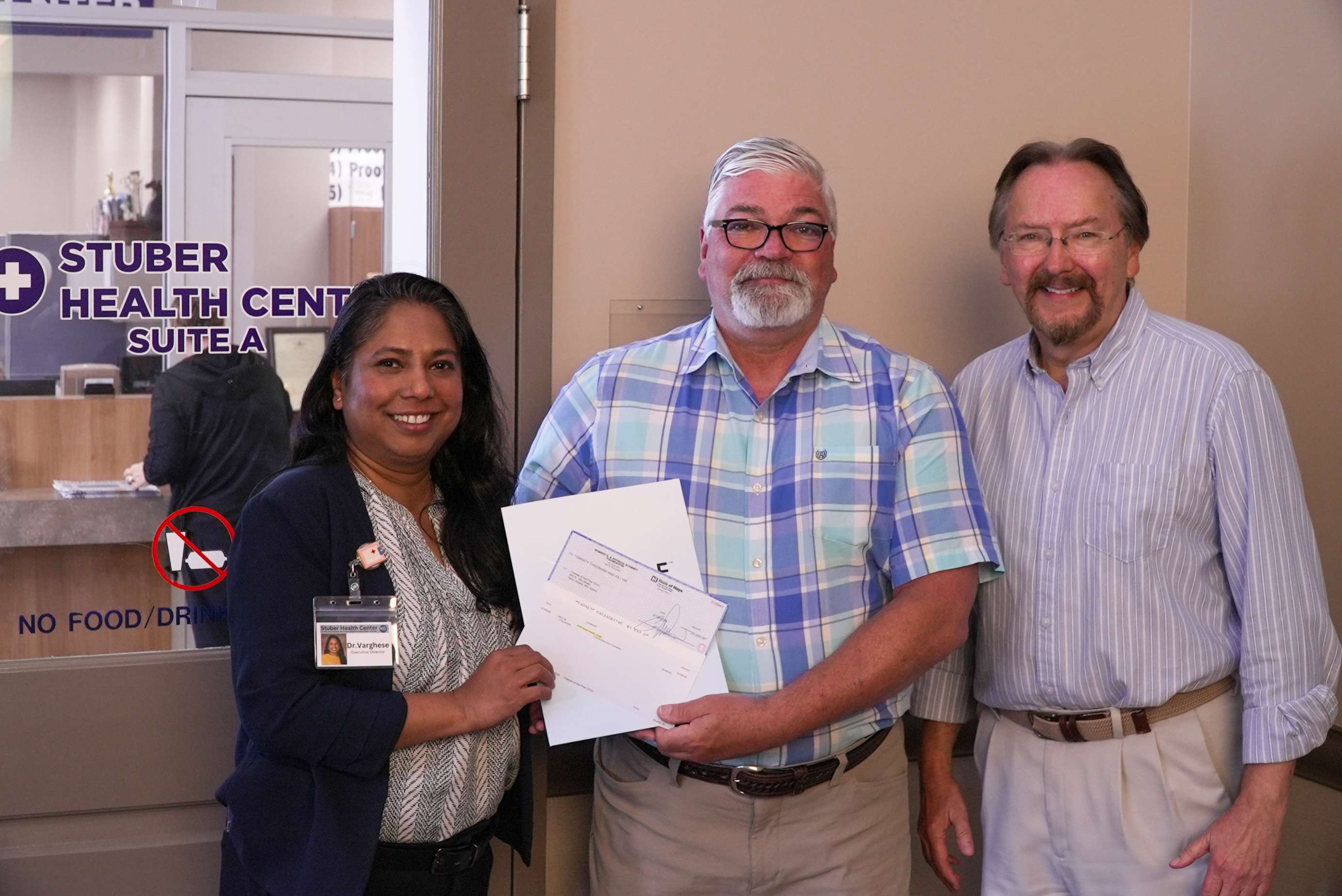 St. Joseph Eagle Radio General Manager Kevin Waltman (center) presents Rex Robinson President of the Board of Directors for Stuber Health Center and Executive Director Dr. Latha Varghese (left) with a check from the Schmidt Foundation Photo by Justin Peacock