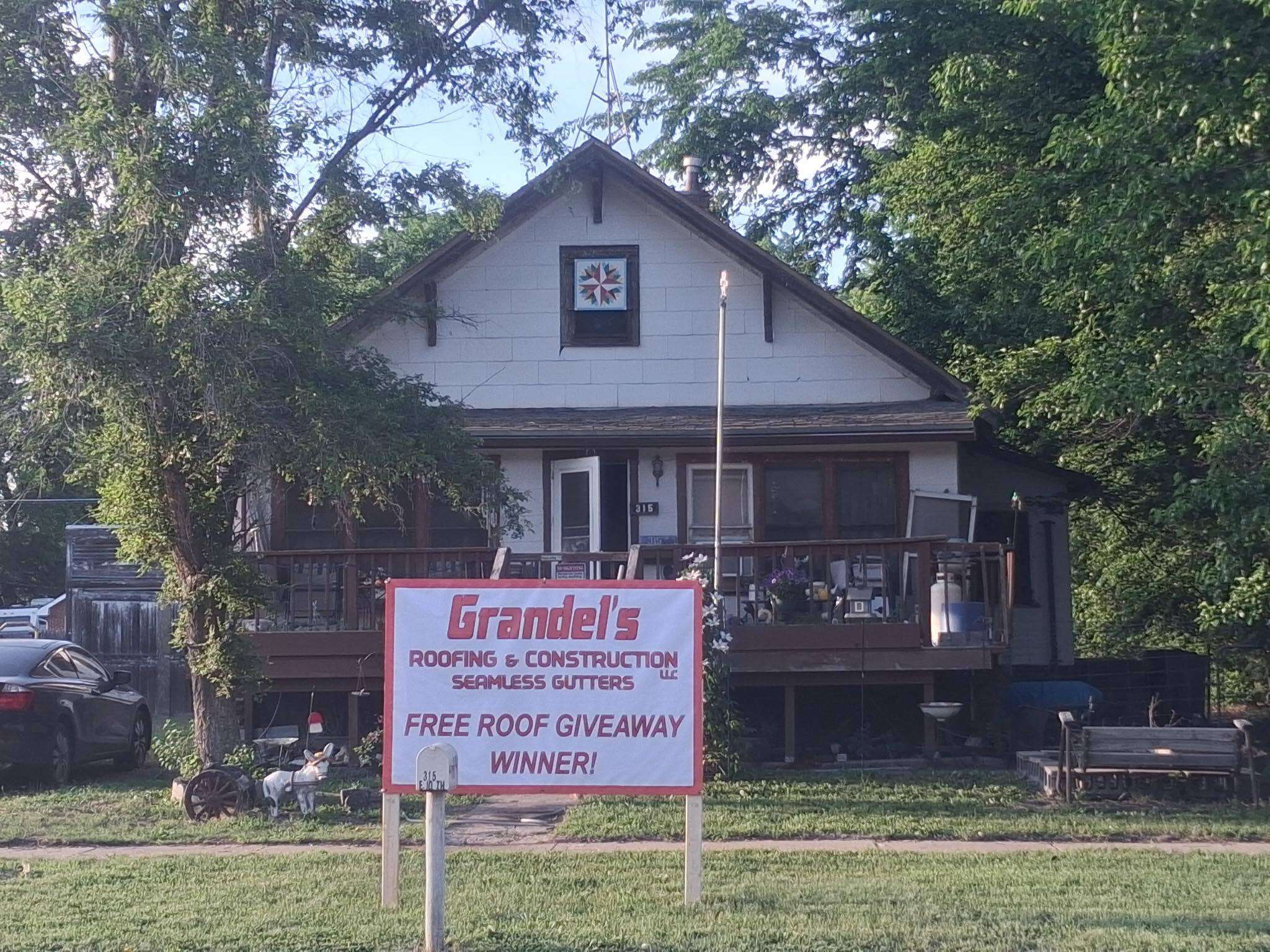 A sign announcing the winner of Grandel's Roofing and Construction's annual free roof giveaway stands in front of the North Platte home of Rick and Glenda Roasch. The couple was selected after a nomination detailed years of ongoing health challenges and the need for a new roof at their residence. (Grandel's Roofing &amp; Construction)
