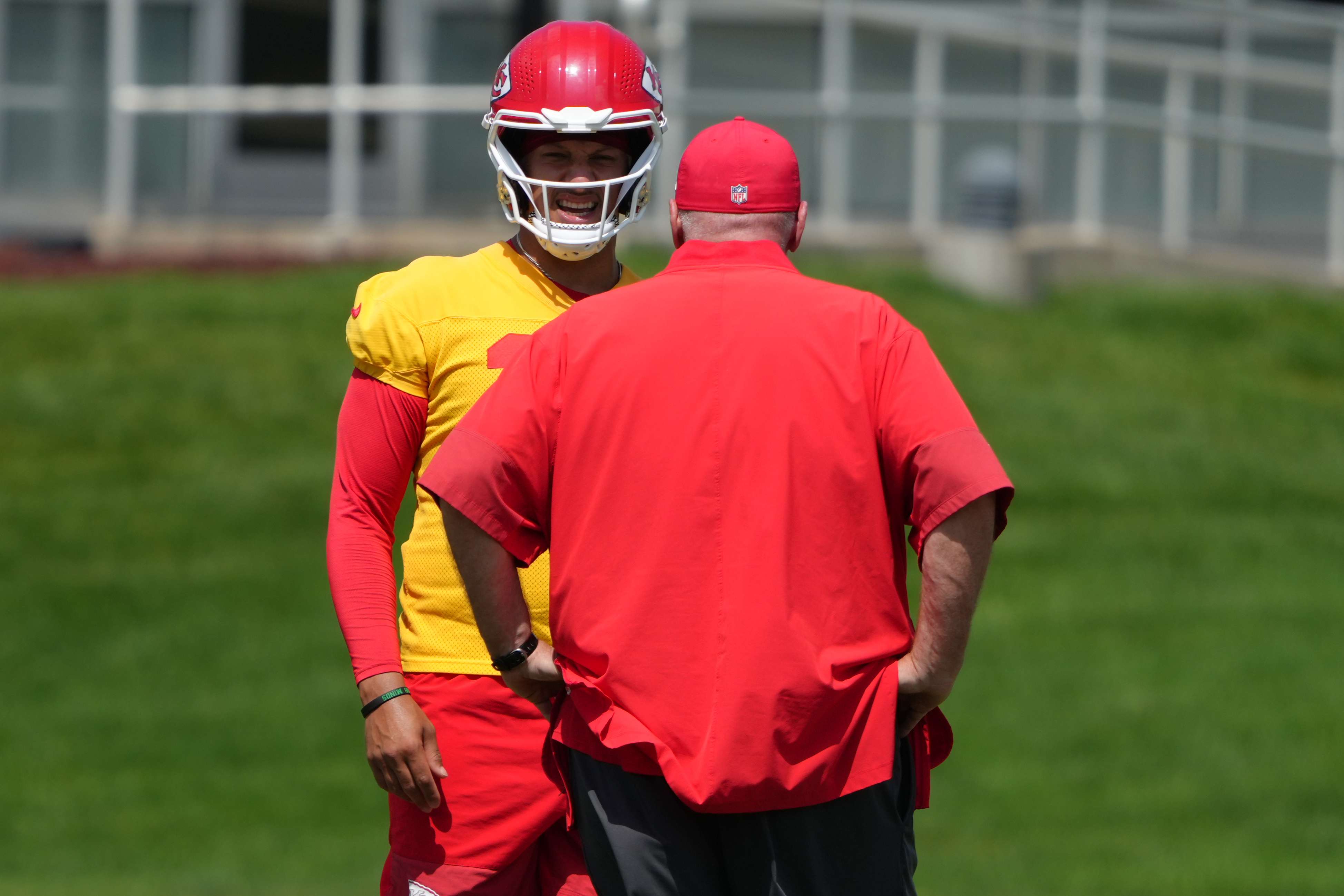 Kansas City Chiefs quarterback Patrick Mahomes, back, talks with head coach Andy Reid during an NFL football team's practice Wednesday, June 10, 2026, in Kansas City, Mo. (AP Photo/Ed Zurga)