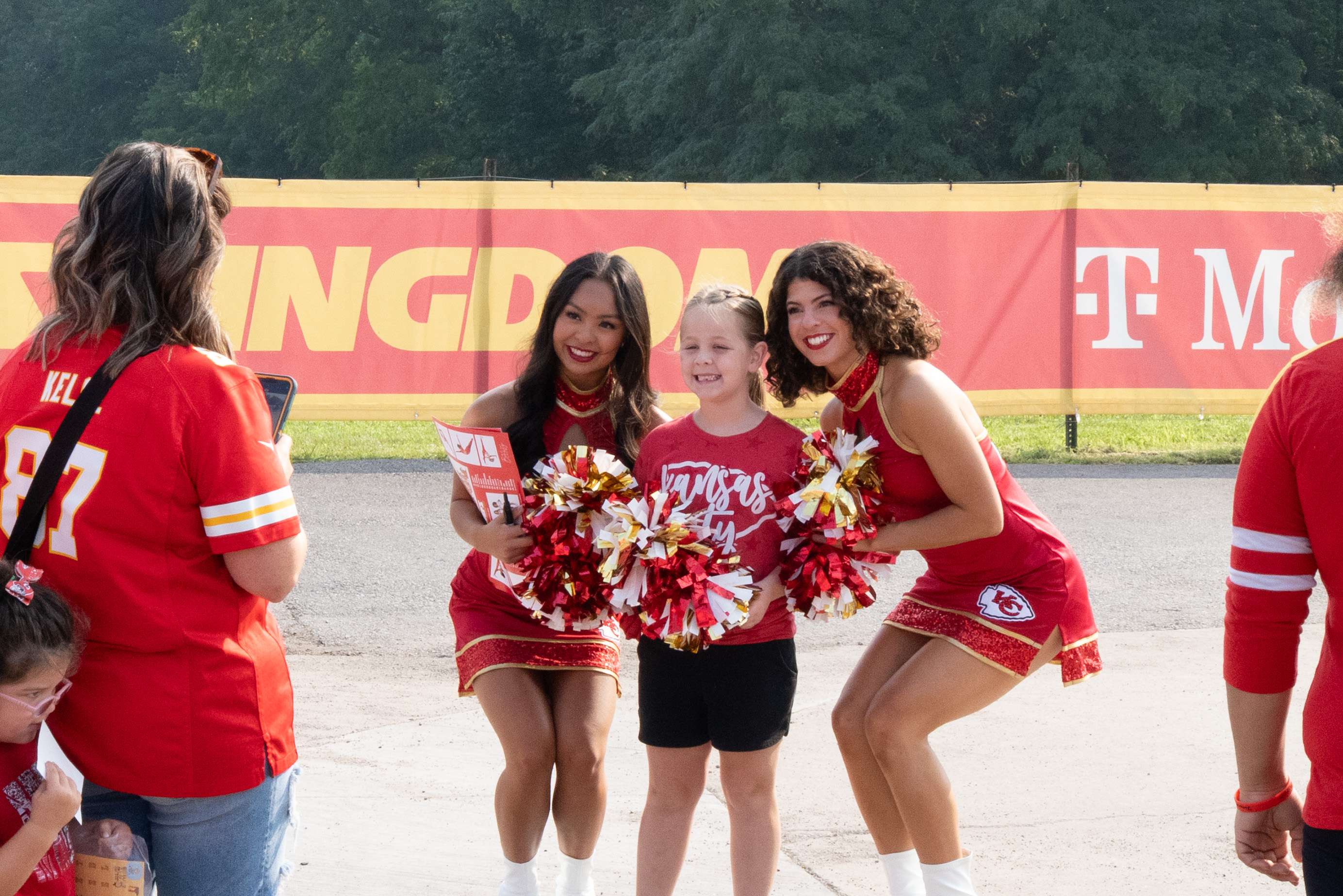 Chiefs cheerleaders pose with a young Chiefs fan during Chiefs training camp on the campus of Missouri Western State University/ Photo by Justin Peacock