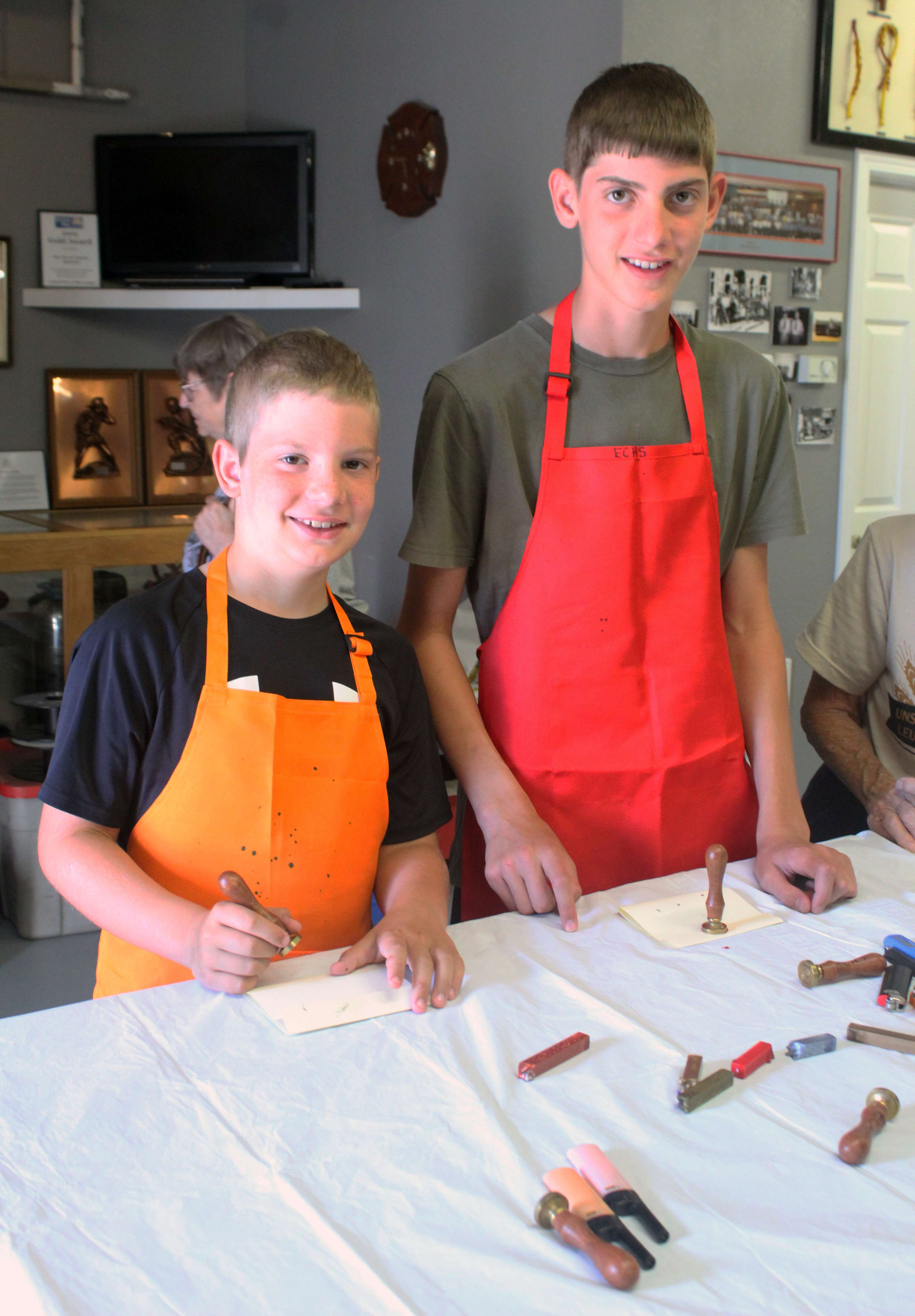 Two boys seal letters using a wax stamp after writing notes using a feather quill.&nbsp;Photo by Cristina Janney/Hays Post
