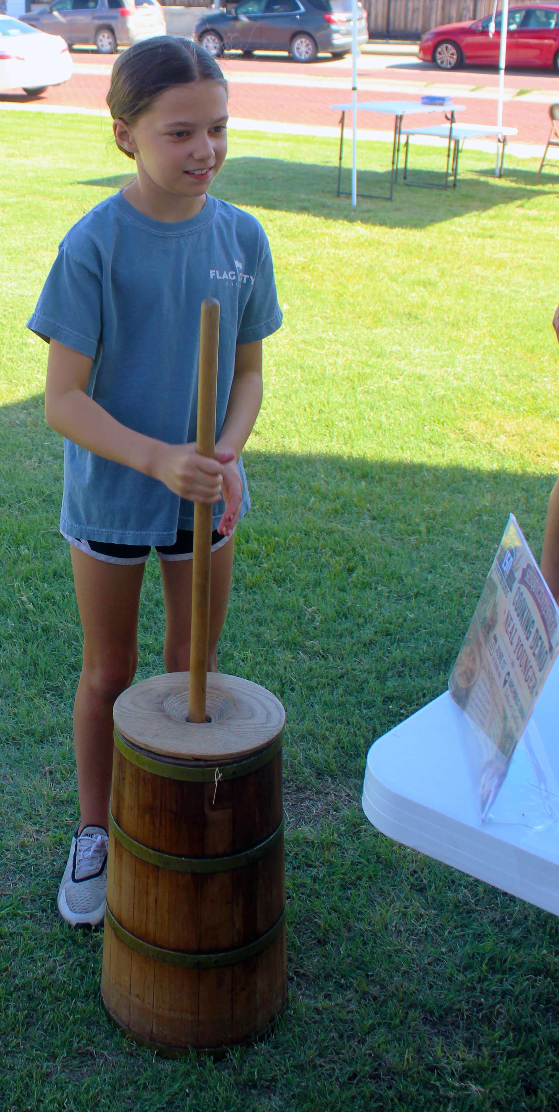 A girl learns about churning butter Saturday at Kinderfest. Churning butter was usually children's work, and the children of the family often had to churn for several hours to make enough butter for the family.&nbsp;Photo by Cristina Janney/Hays Post