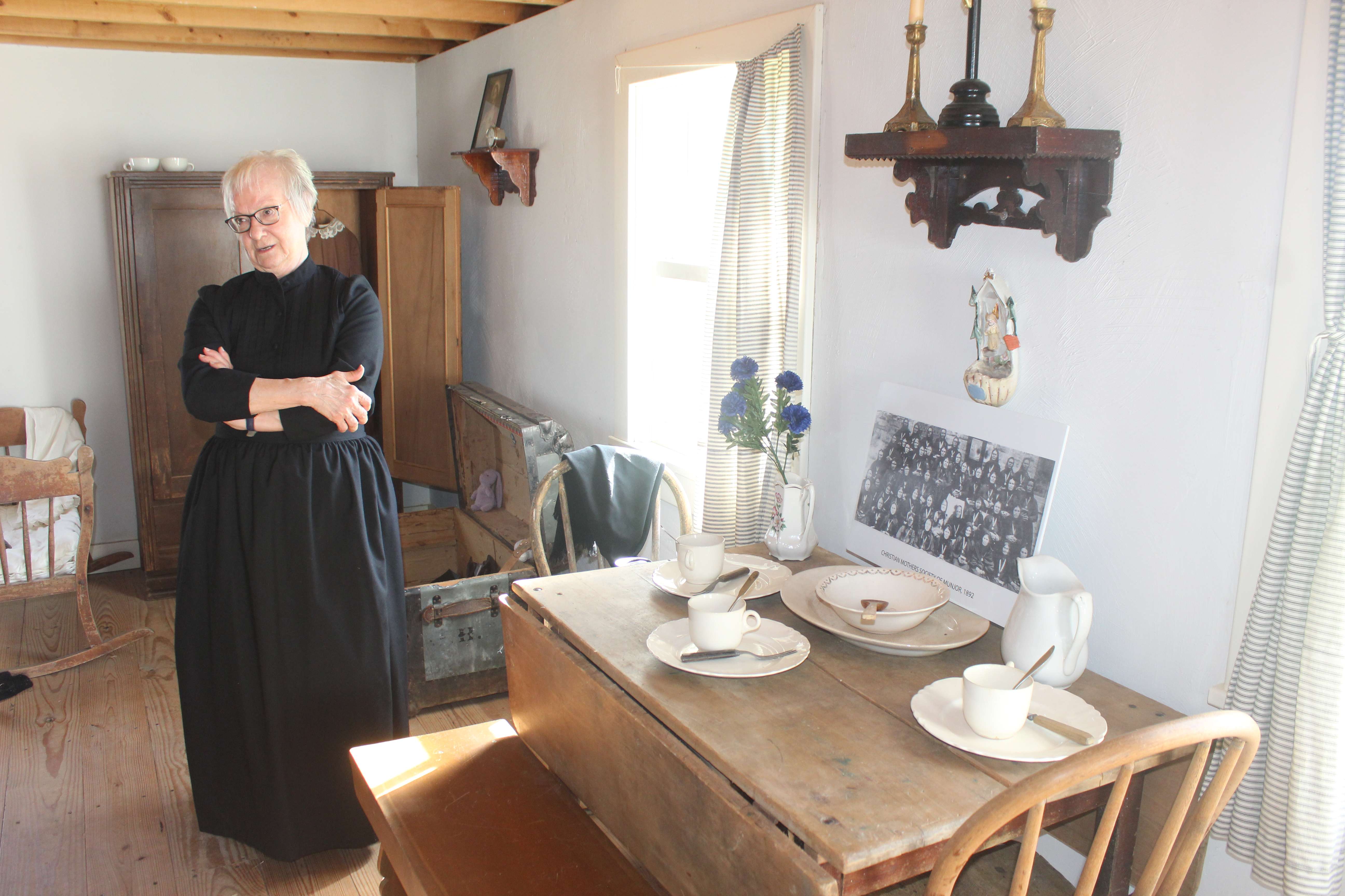 A re-enactor&nbsp; leads a tour of the Volga German house on the historical society grounds in Hays. Large families often only had one table on which to eat and took turns using the small space.&nbsp;Photo by Cristina Janney/Hays Post