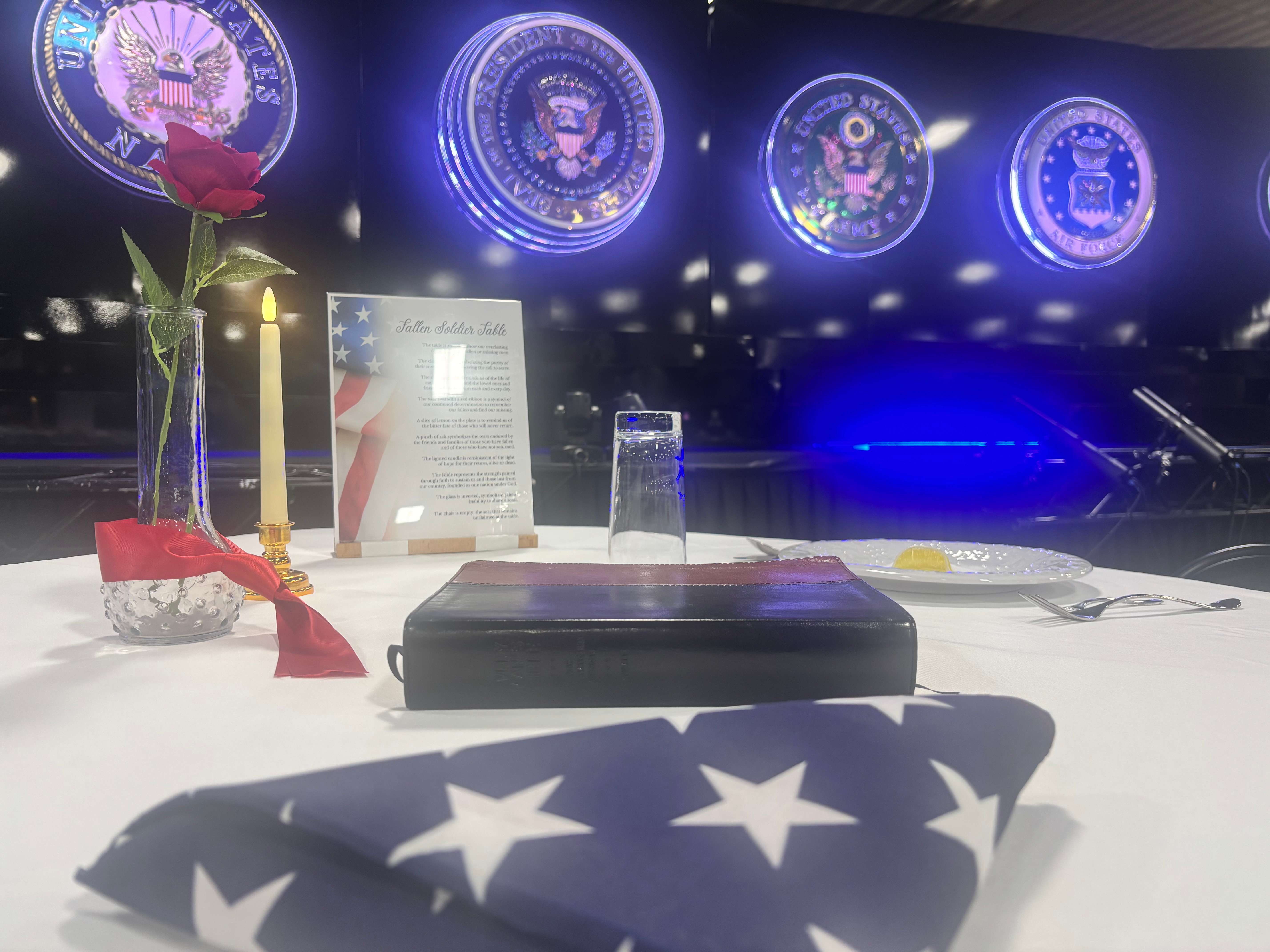 A Missing Man Table, featuring a folded American flag, Bible, candle and other symbolic items, honors military personnel who never returned home. The display is one of several featured as part of Patriot Thunder's Wall of Heroes exhibit. (Allison Peck | The Post)