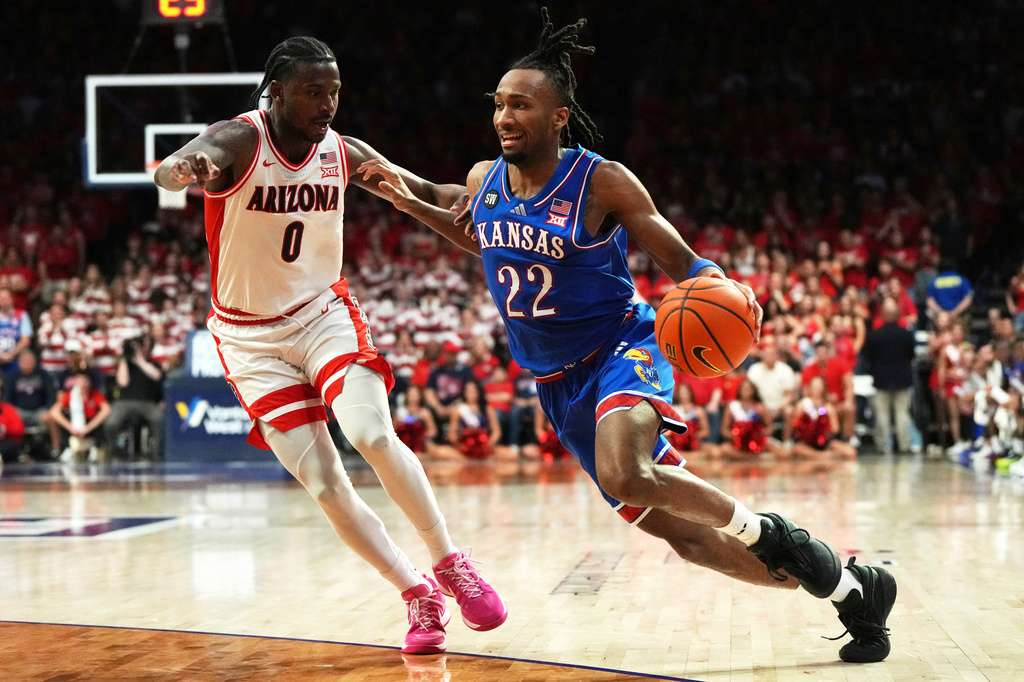 Kansas guard Darryn Peterson (22) works against Arizona guard Jaden Bradley (0) during the first half of an NCAA college basketball game against Arizona, Feb. 28, 2026, in Tucson, Ariz. (AP Photo/Rick Scuteri)