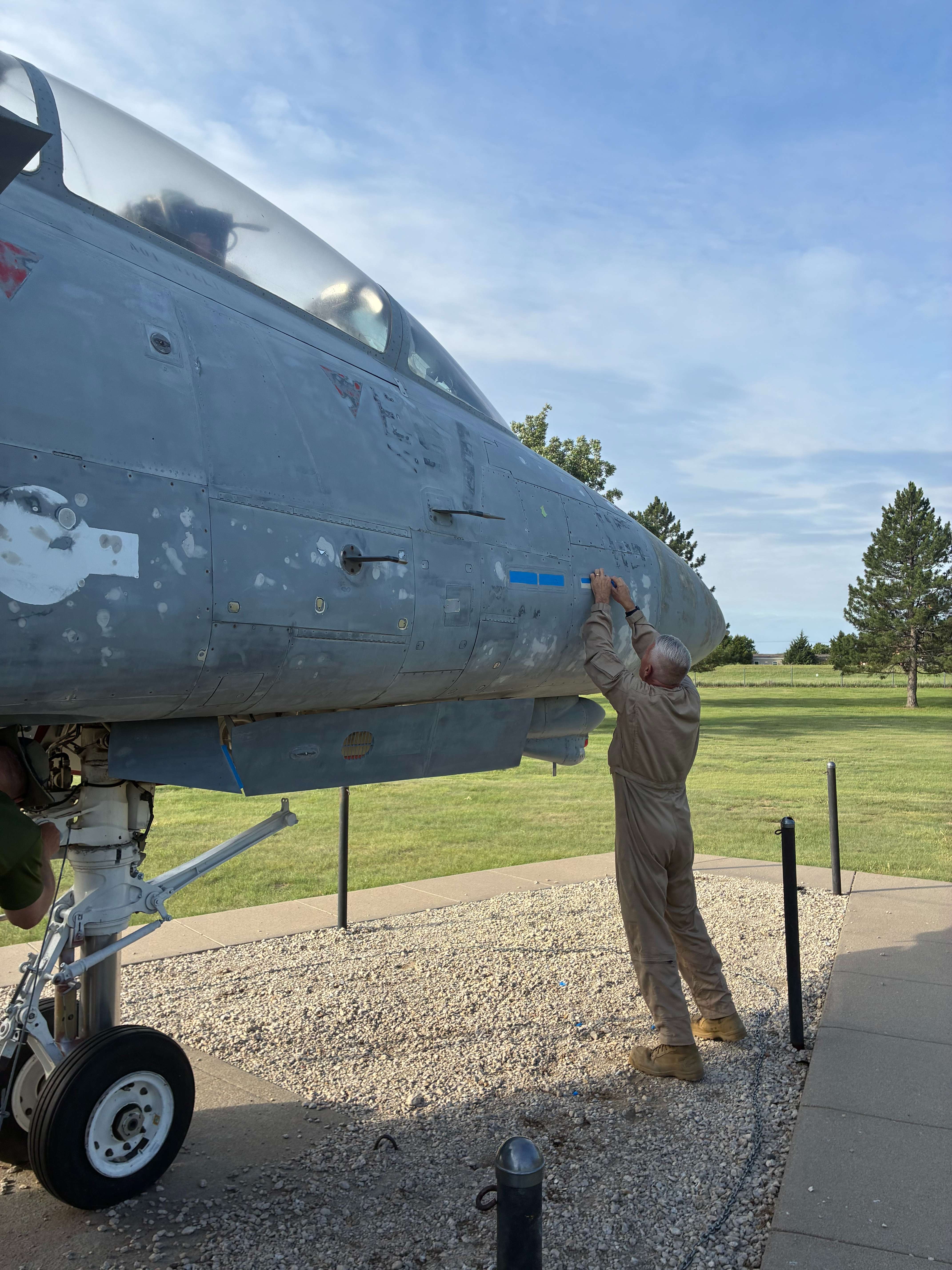 Martin Byfield, Hays native and Utilitiesman First Class putting tape over the front of the plane as they get ready to repaint the F14 Tomcat. Photo by Alin Hett/Hays Post