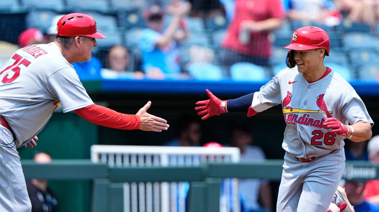St. Louis Cardinals' JJ Wetherholt (26) celebrates with third base coach Ron 'pop' Warner (75) after hitting a solo home run during the first inning of a baseball game against the Kansas City Royals, Sunday, June 21, 2026, in Kansas City, Mo. (AP Photo/Charlie Riedel)