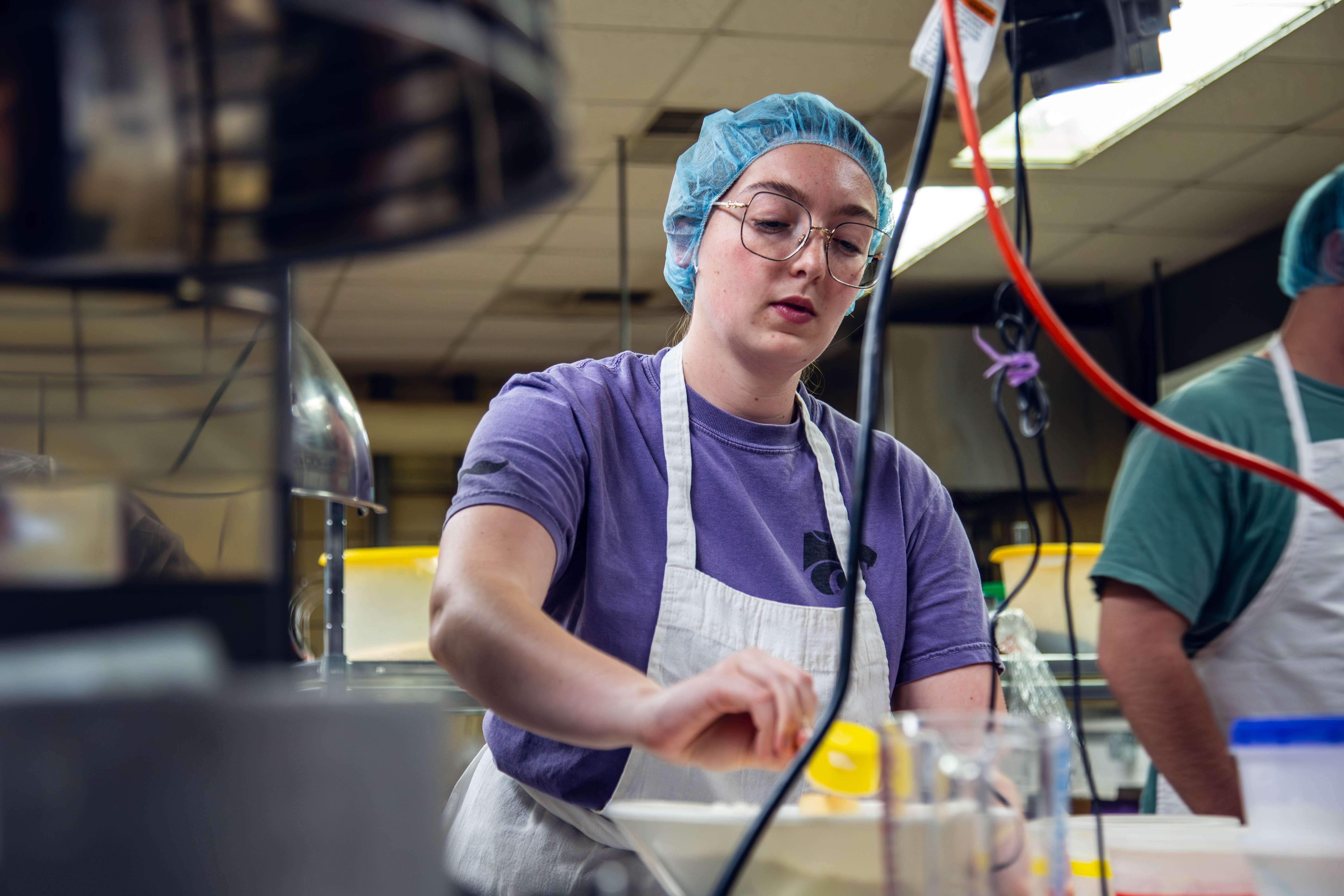 Addison Brandau measures out ingredients for an experimental sorghum muffin recipe - Kristina Bonner/Division of Communications and Marketing.