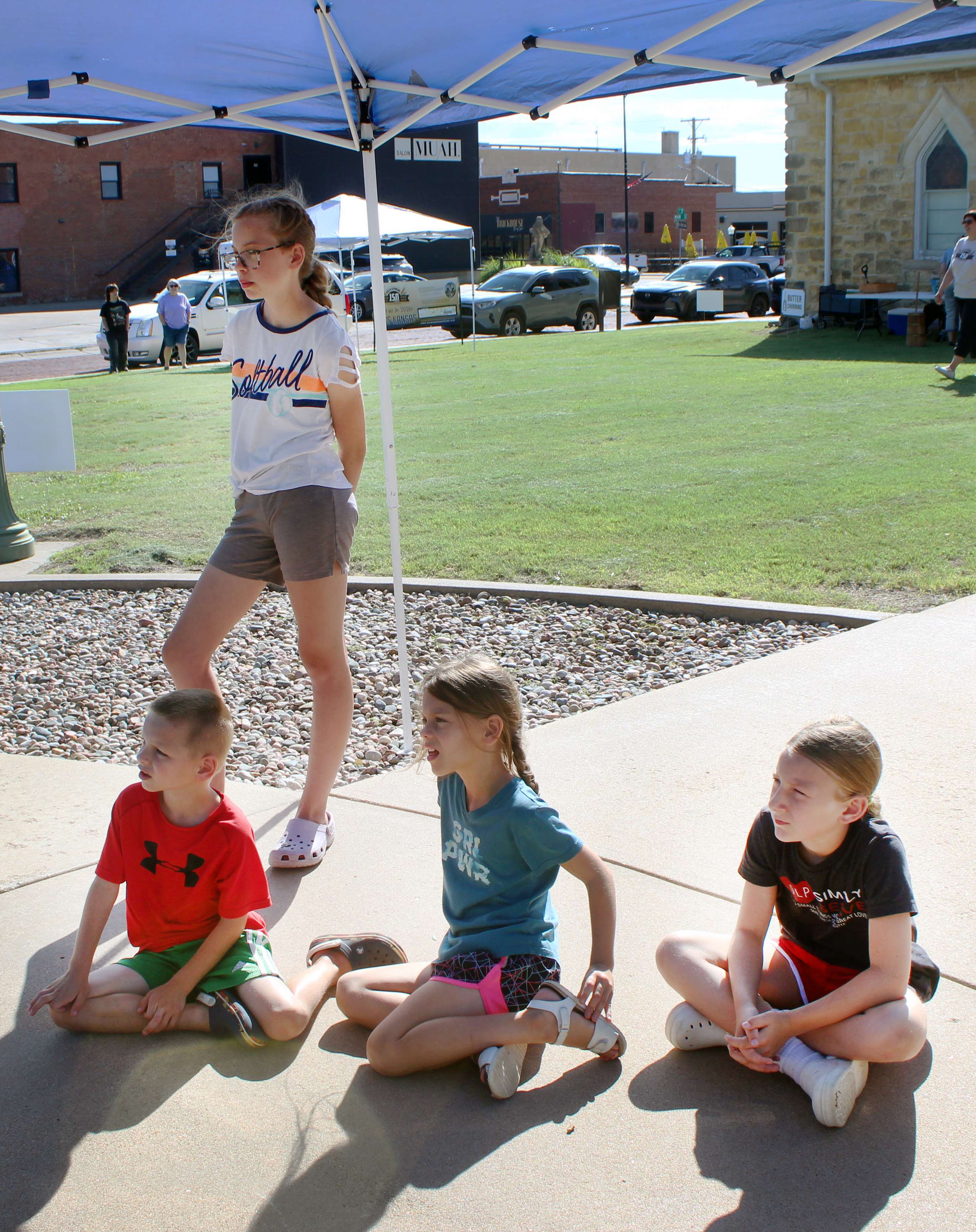A group of children listen to "Tom and the Farm"&nbsp;and "The Blue Dress," which were written and illustrated by Hays High students on June 13 at Kinderfest at the Ellis County Historical Society. The books are based on the lives of local Volga German families.&nbsp;Photo by Cristina Janney/Hays Post