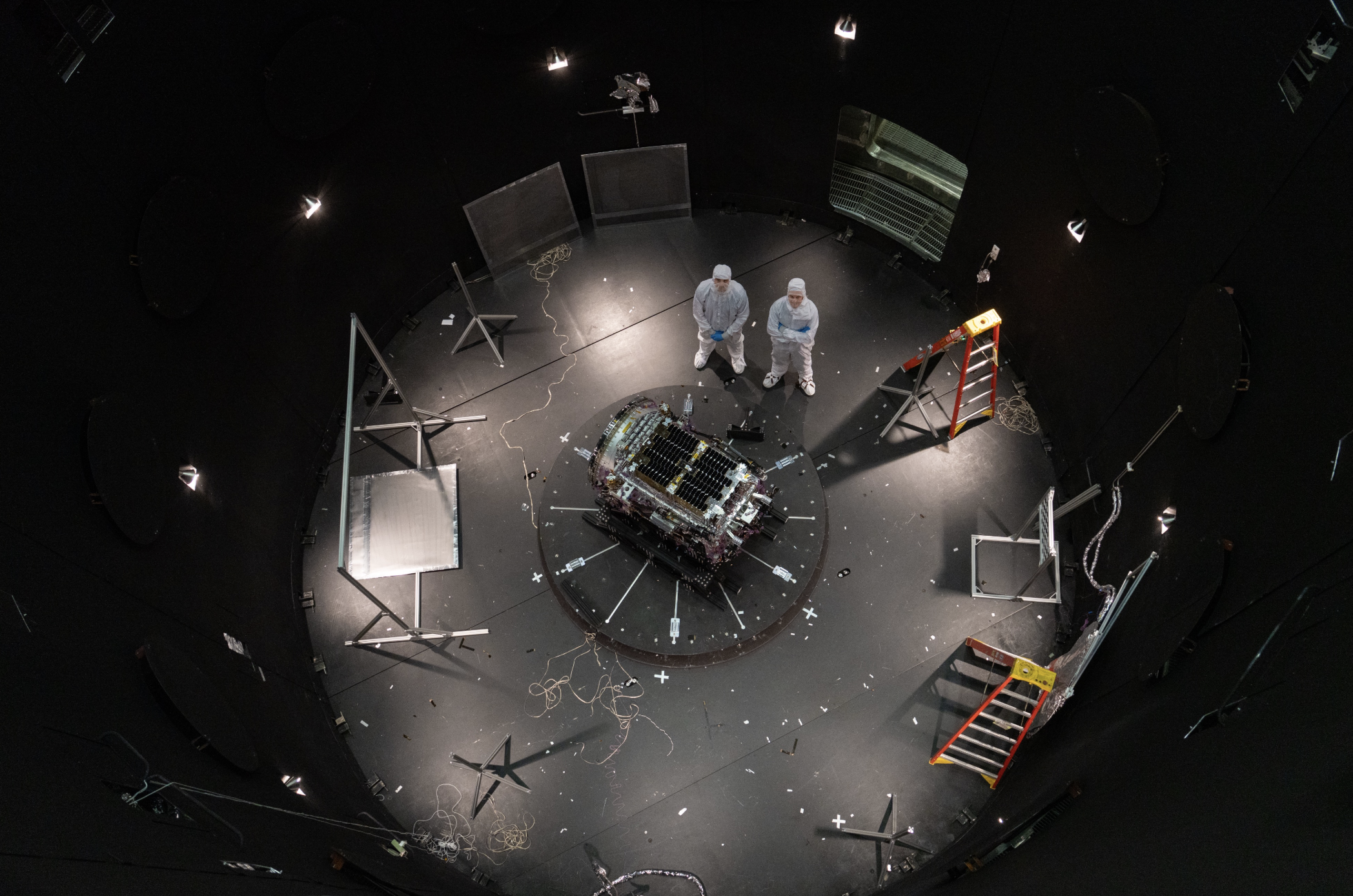This photo provided by NASA shows Kieran Wilson, LINK’s principal investigator, and Hunter Robertson, a space systems engineer, both at Katalyst Space, standing next to their spacecraft inside the SES (Space Environment Simulator) at NASA’s Goddard Space Flight Center in Greenbelt, Md., April 17, 2026, ahead of thermal vacuum testing. (Sophia Roberts/NASA 