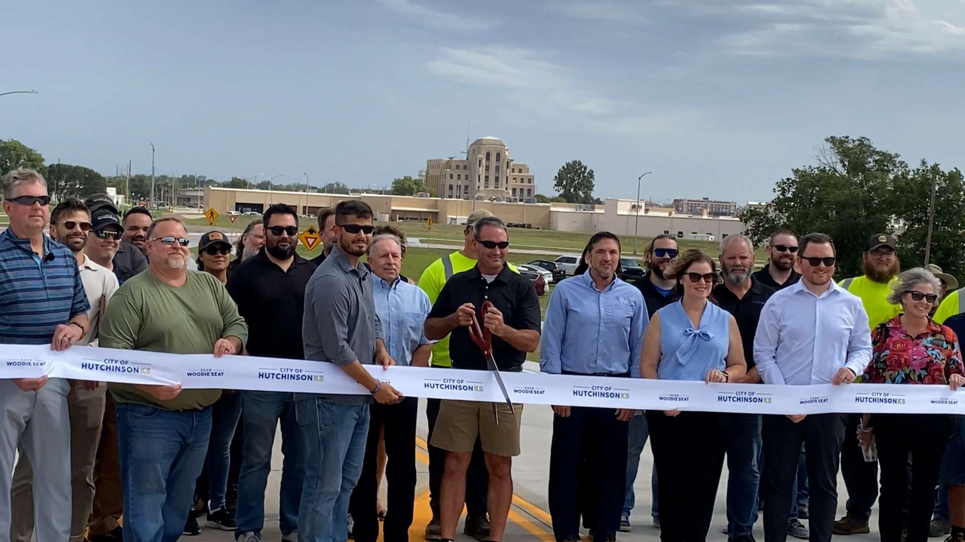 Mayor Scott Meggers cuts the ribbon during today's ceremony reopening the Woodie Seat Freeway. (Hutch Post photo)