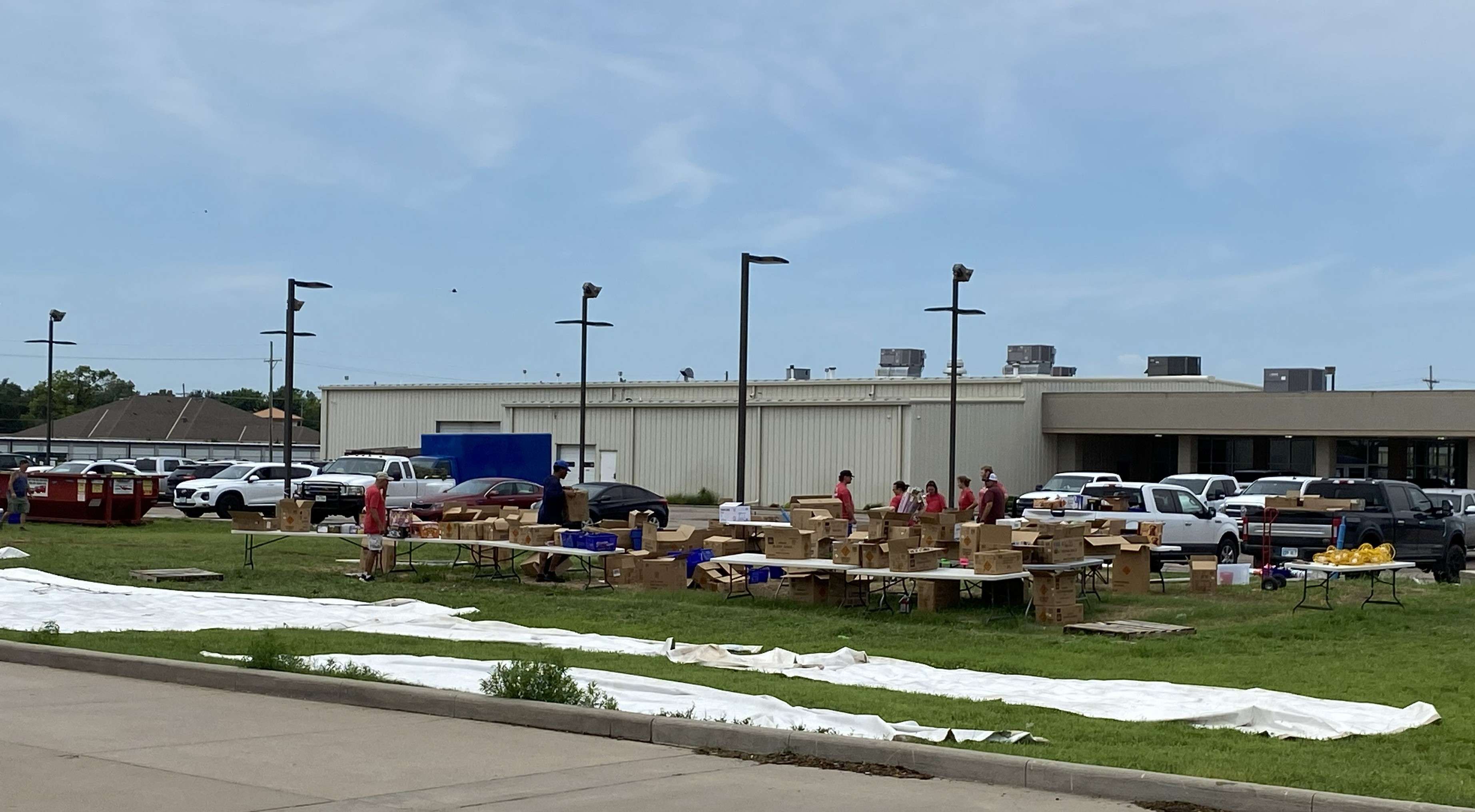 Employees work through what remains of their fireworks tent on east 30th Avenue after storms moved through the city early on Saturday morning. (Hutch Post photo)