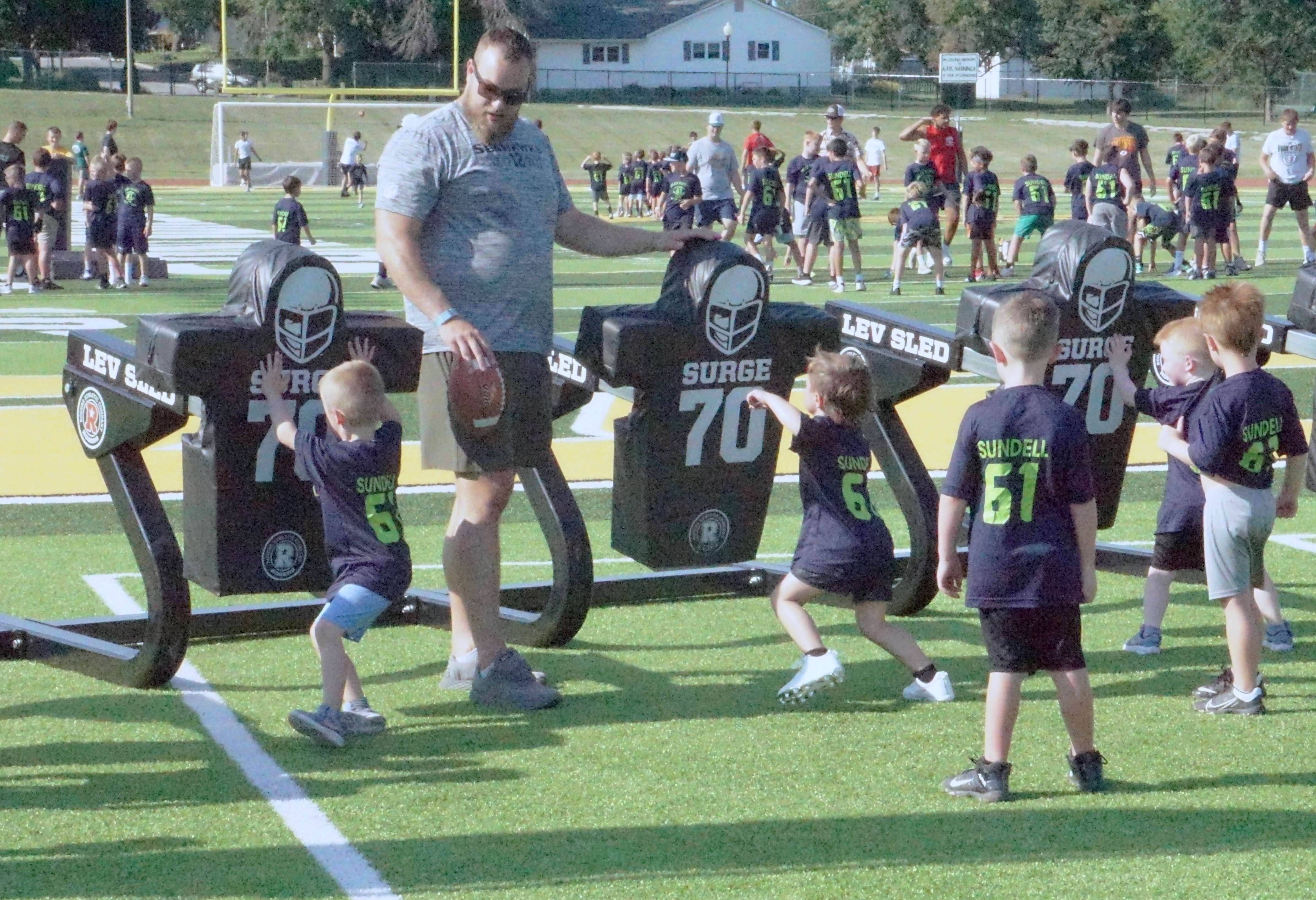 Jalen Sundell walks a group through a sled hitting offensive line drill/Photo by Matt Pike