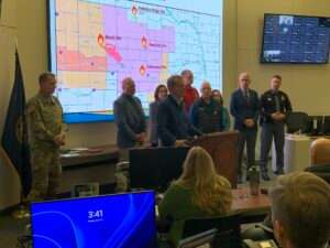 Nebraska Gov. Jim Pillen, center, leads a news briefing regarding ongoing fires across the state on March 16, 2026, from the headquarters of the Nebraska Emergency Management Agency. (Photo courtesy of the Nebraska Governor’s Office)