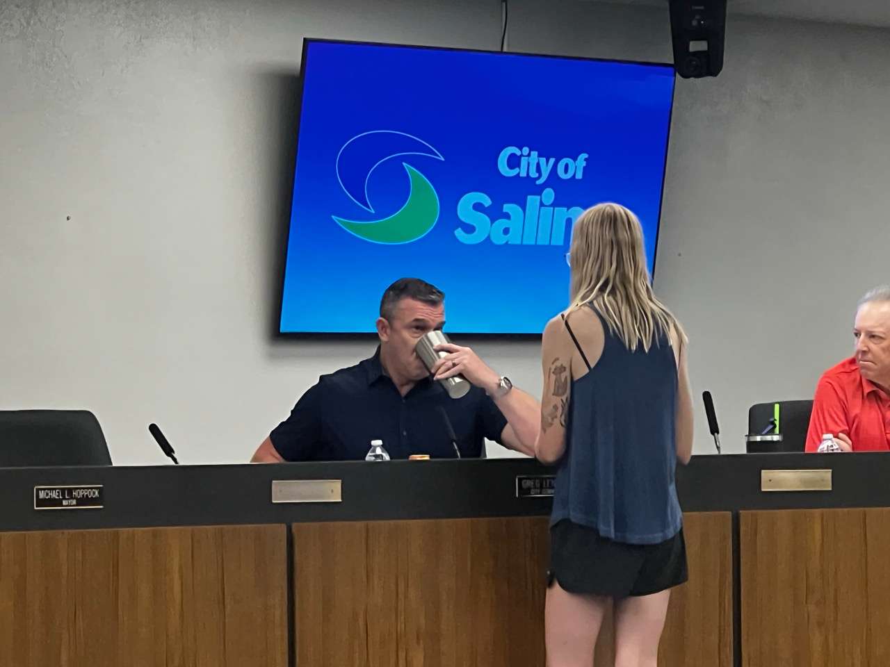 Commissioner Greg Lenkiewicz drinks water from a cup that belonged to a community member, which was filled with water from the building's sink during the July 13, 2026, Salina City Commission meeting. Before this, the resident spoke during the public comment period and said, "The city (Salina) water that I grew up drinking straight out of the hose has only gotten worse and worse. So people demanding change now, I demand that someone drink this once I fill it from the restroom sink." - Photo, Nicolas Fierro