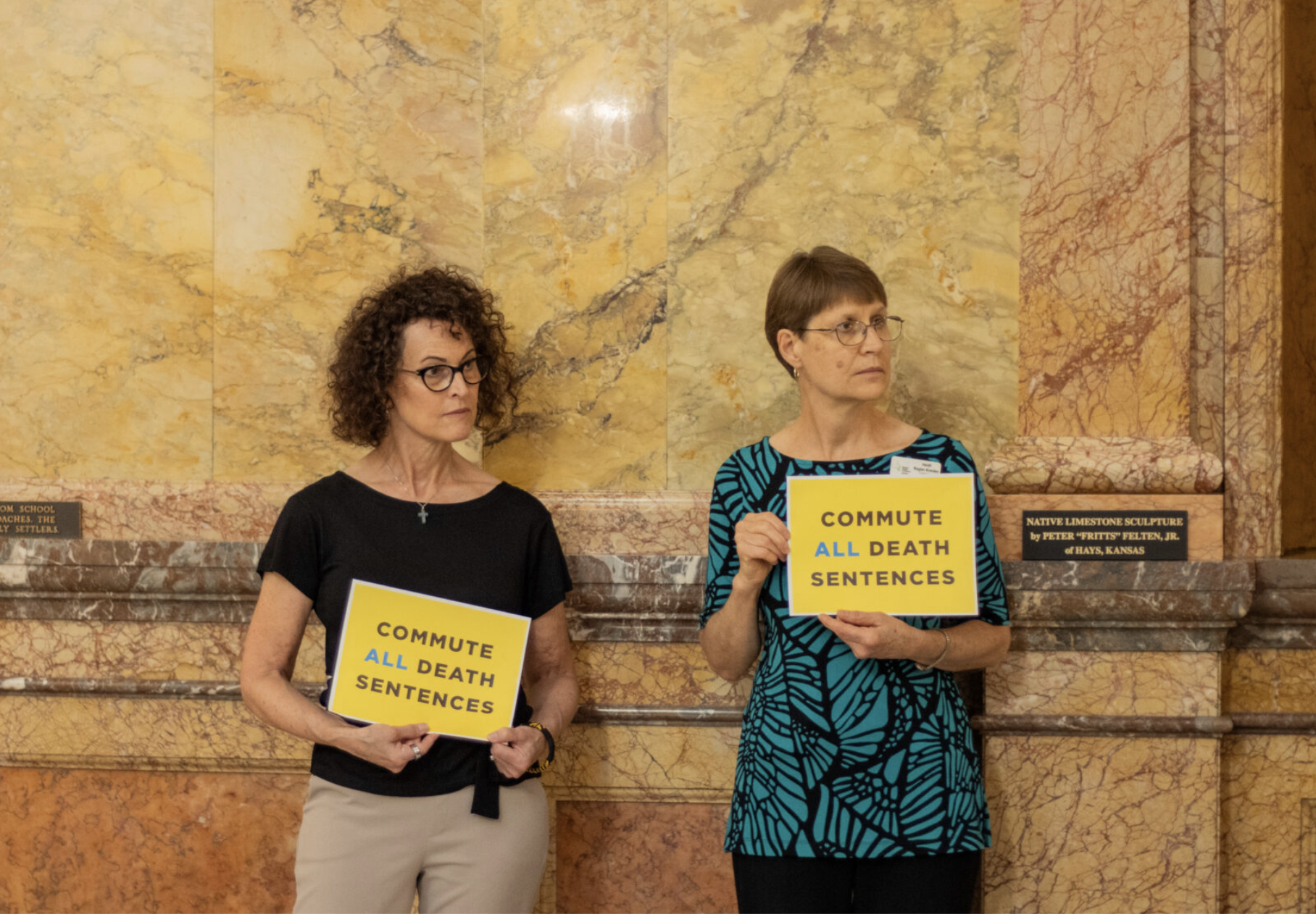  Faith-based activists Jennifer Montgomery, left, and Heidi Regier Kreider call the Kansas governor to accept the clemency requests of death row inmates at the Statehouse in Topeka on July 14, 2026. (Photo by Baya Burgess/ Kansas Reflector)