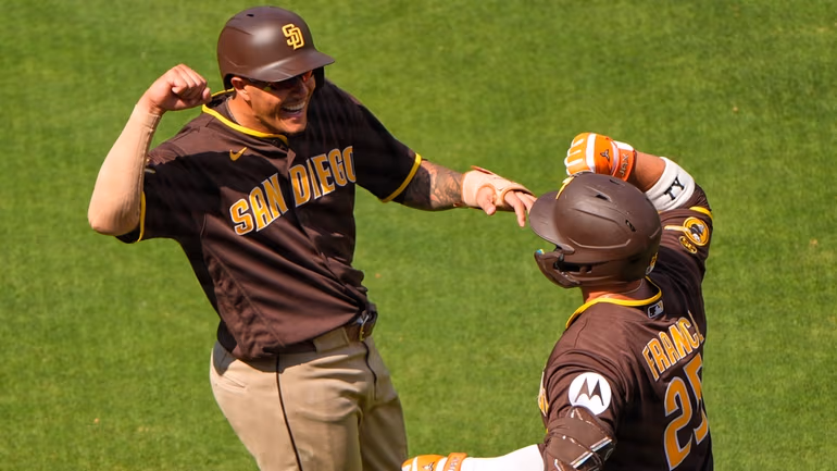 San Diego Padres' Ty France (25) celebrates with Manny Machado, left, after hitting a grand slam during the eighth inning of a baseball game against the Kansas City Royals, Sunday, July 19, 2026, in Kansas City, Mo. (AP Photo/Charlie Riedel)