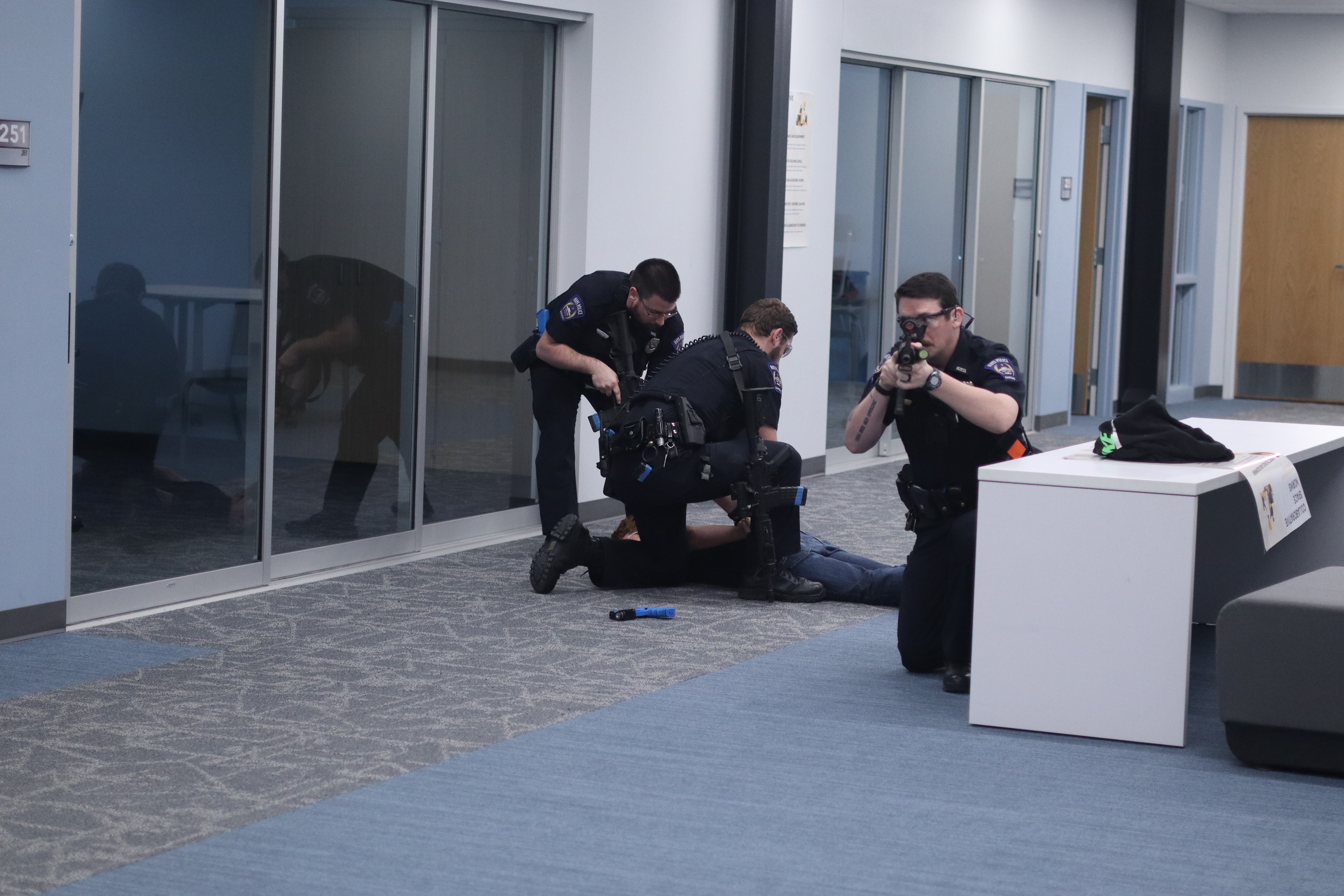 Officers Caleb Koehn, Officer Joseph Lantz and Officer Tate Bartlett arresting acting suspect Ethan Dague during the active shooter training exercise at Hays High School on Tuesday. Photo by Alin Hett/Hays Post. &nbsp;