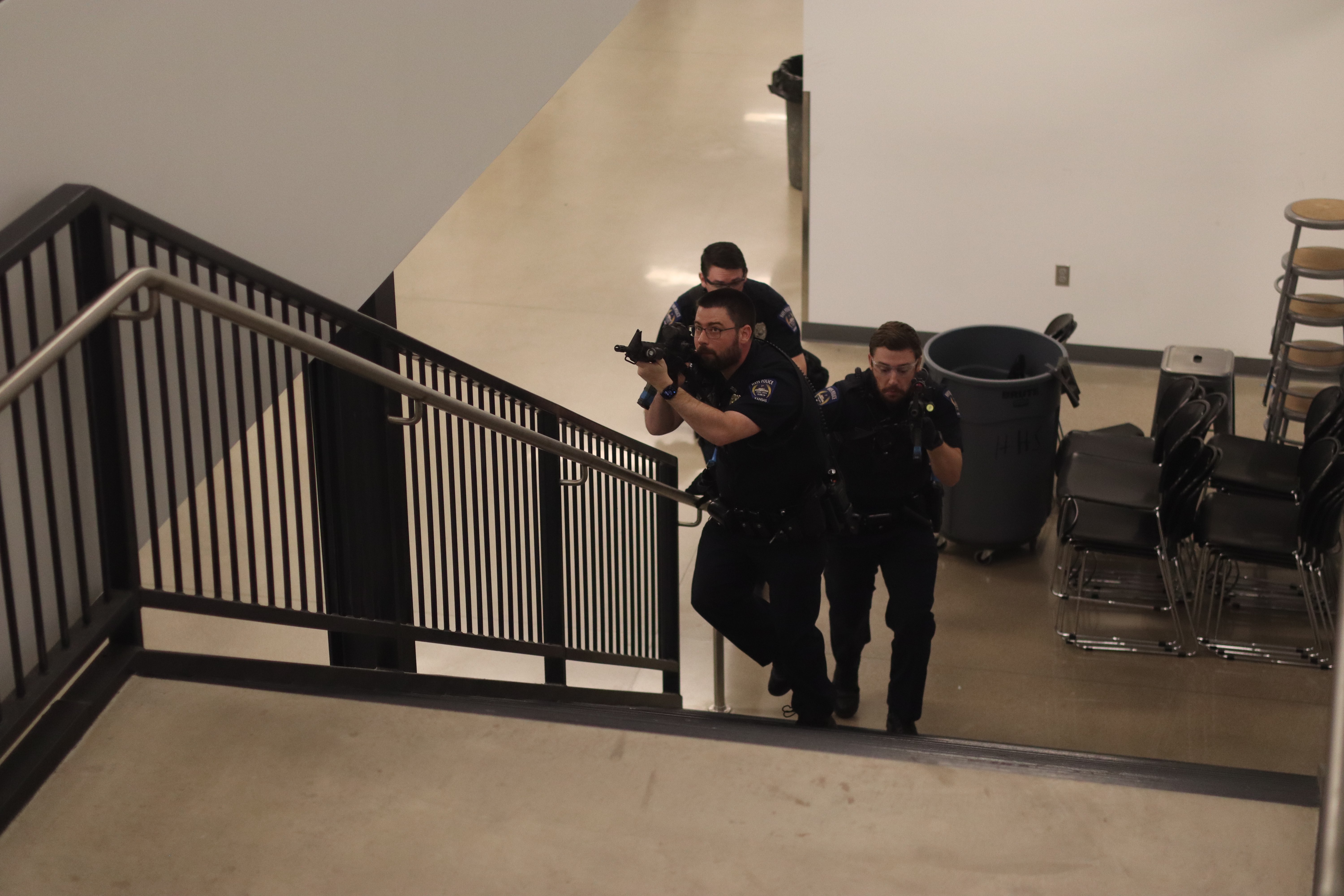 Hays Police Department officers clear a stairwell during an active shooter training exercise at Hays High School, practicing response tactics for a potential emergency situation.<br>