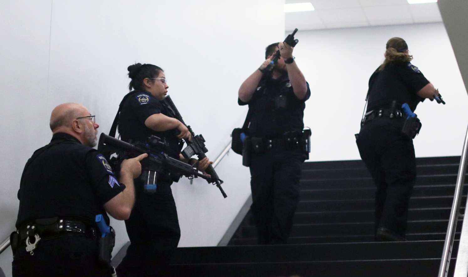 Hays Police Department officers clear a stairwell during an active shooter training exercise at Hays High School, practicing response tactics for a potential emergency situation.<br>