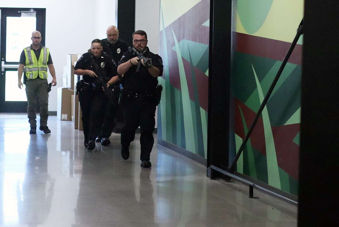 Hays Police Department officers clear a hallway during an active shooter training exercise at Hays High School designed to improve emergency response skills.<br>