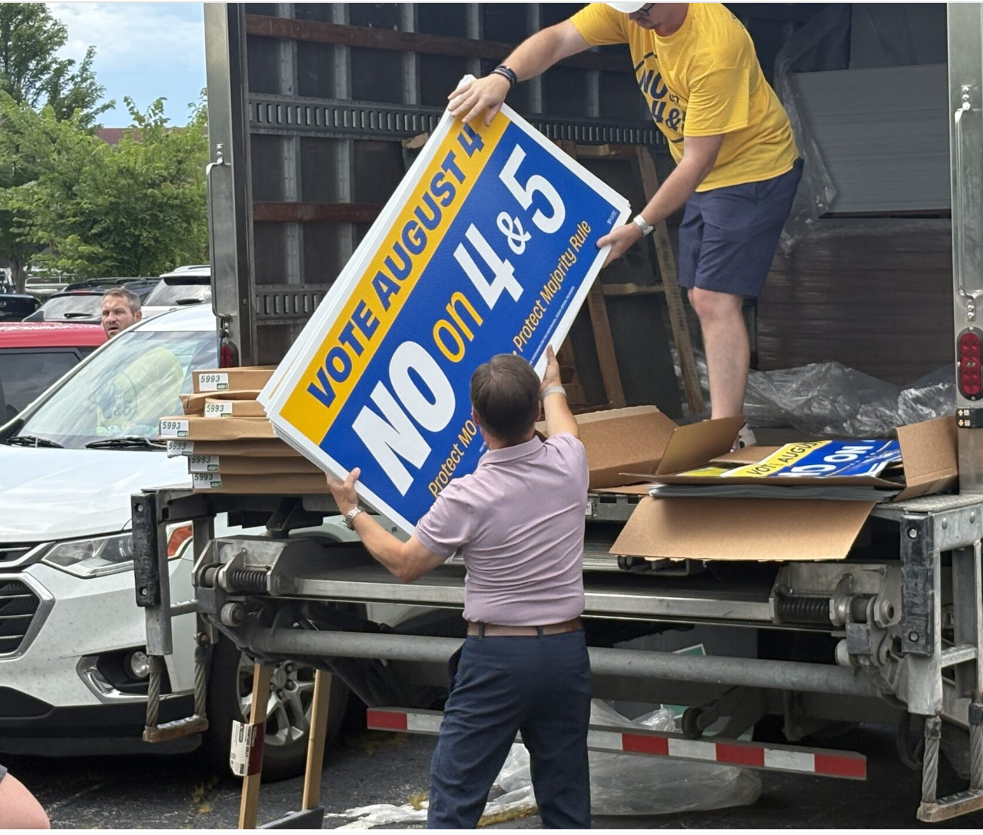 Members of the Missouri Association of Realtors unload signs urging voters to reject Amendments 4 and 5 after a rally in Columbia on July 9 (Jason Hancock/Missouri Independent).