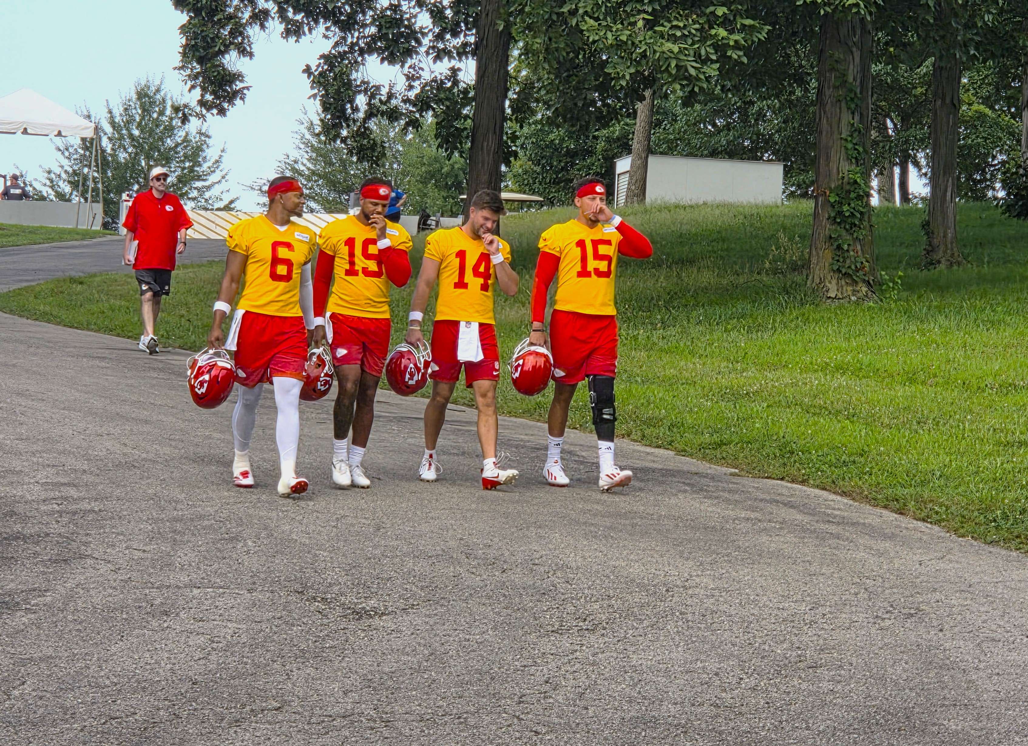 The quarterback group, Patrick Mahomes (15), Justin Fields (6), Chris Oladokun (19), and Garrett Nussmeier (14), walk down the hill together to practice/ Photo by Matt Pike