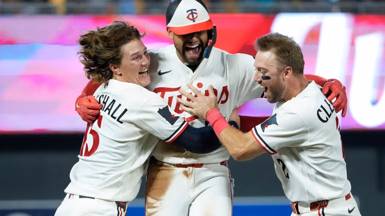 Minnesota Twins' Royce Lewis, center, celebrates with Luke Keaschall, left, and Kody Clemens after hitting an RBI triple walk-off scoring Victor Caratini and Brooks Lee in the ninth inning of a baseball game against the Kansas City Royals, Tuesday, July 28, 2026, in Minneapolis. (AP Photo/Joseph Scheller)