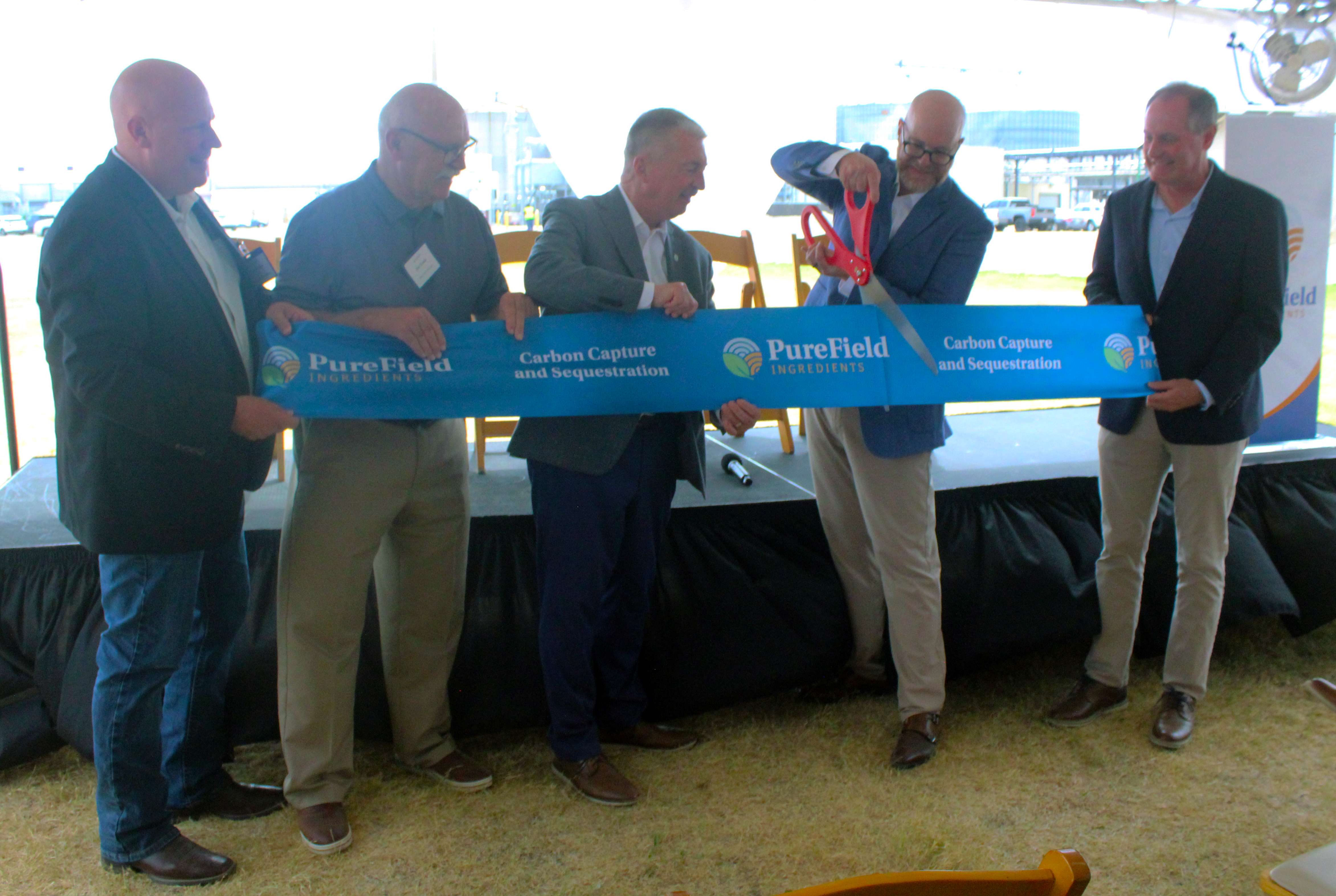 From left Kansas Wheat Commission CEO Justin Gilpin, Russell Mayor Jim Cross,&nbsp;EPA Region Seven Administrator Jim Macy, PureField CEO Aaron Buettner (cutting ribbon), and Rep. Tracey Mann, R-Kansas, at a ceremony Wednesday&nbsp; opening the Russell plant's&nbsp;carbon sequestration project. Photo by Cristina Janney/Hays Post