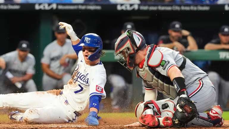 Kansas City Royals' Bobby Witt Jr. (7) beats the tag by Minnesota Twins catcher Ryan Jeffers to score on a fielder's choice hit into by Jac Caglianone during the fifth inning of a baseball game Tuesday, Aug. 4, 2026, in Kansas City, Mo. (AP Photo/Charlie Riedel)
