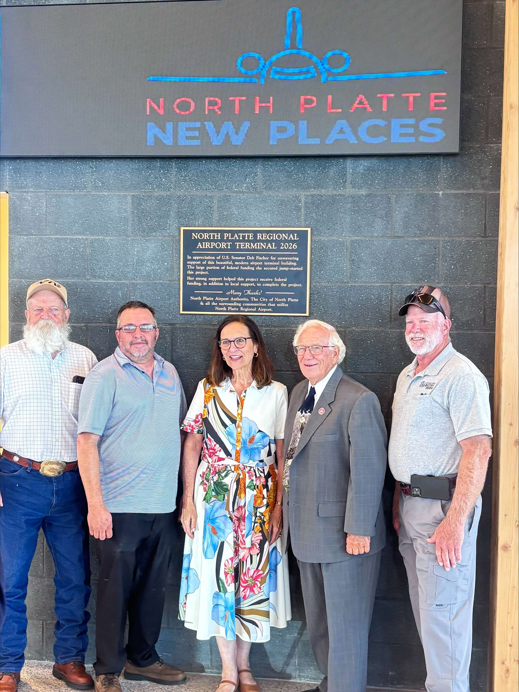U.S. Senator Deb Fischer joins others Monday near a plaque recognizing her support of the new North Platte Regional Airport terminal project during the facility's grand opening. (Allison Peck | The Post)