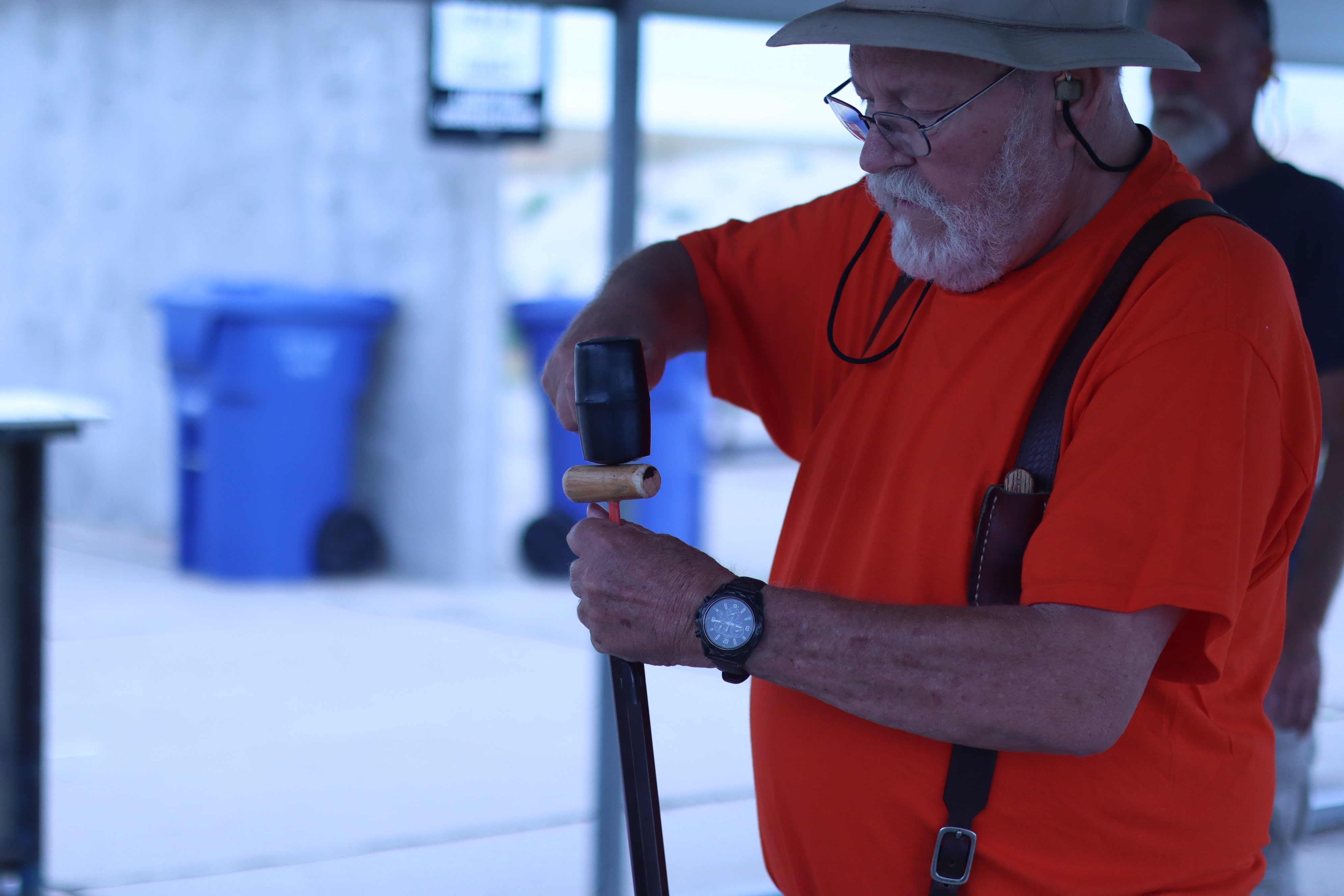 Gerald Thyfault using a mallet to reload a replica of an old rifle.&nbsp;
