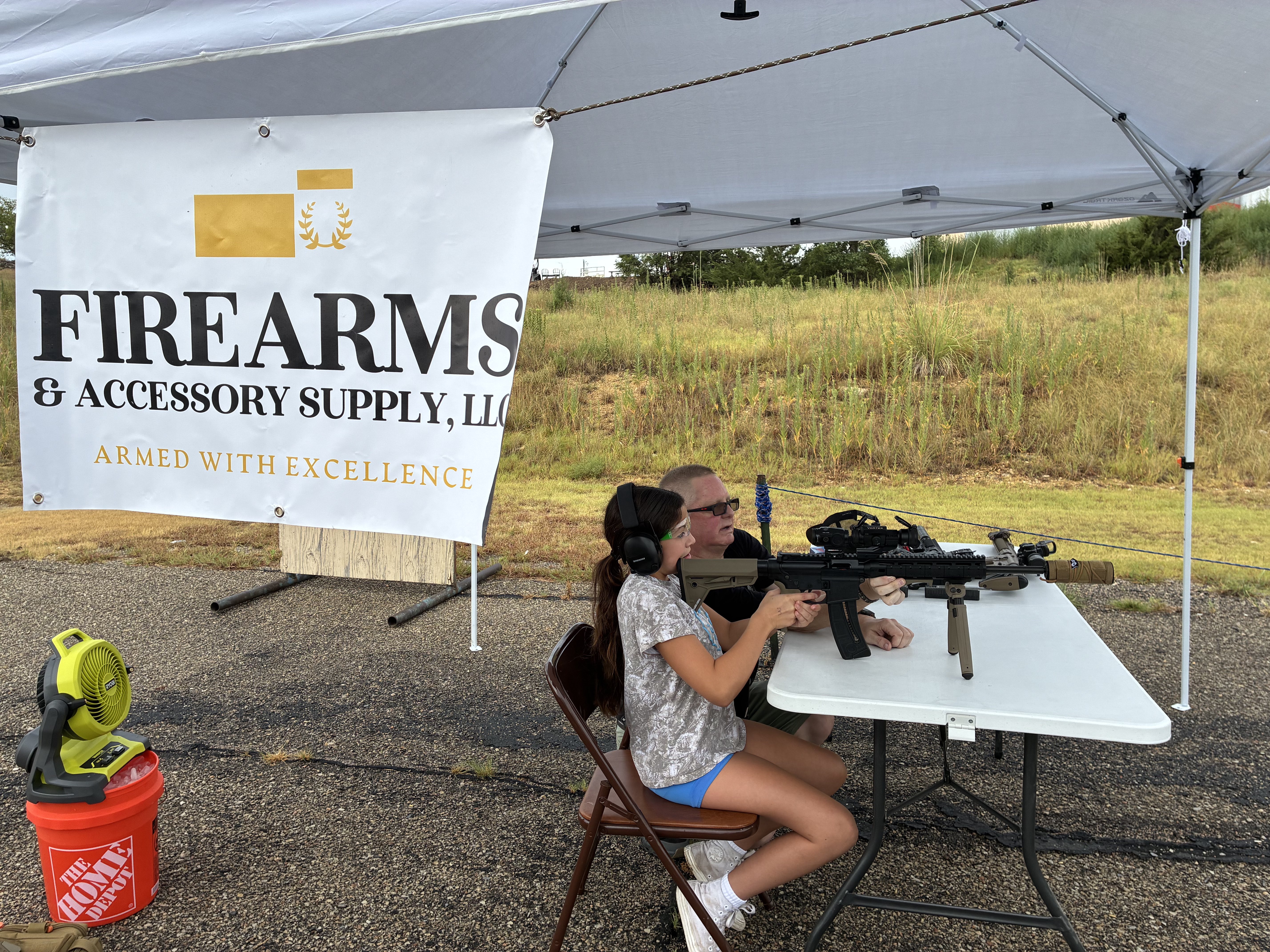 A young participant tries out a Smith &amp; Wesson M&amp;P 15-22 during the 29th annual Youth Outdoor Festival as a FASARMS employee assists her. The rifle was equipped with a bipod and red-dot sight for participants age 12 and older.<br>
