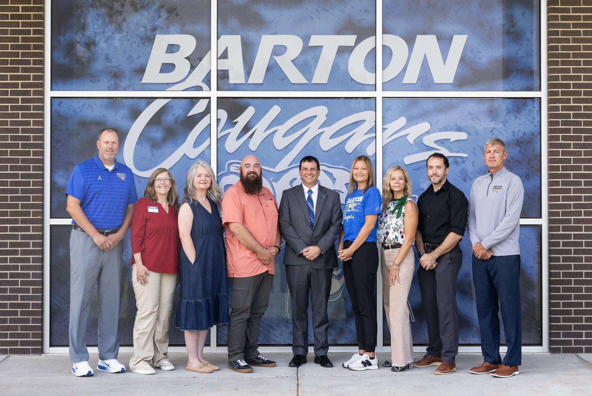 Faculty and Staff join Barton President Dr. Marcus Garstecki for a photo after celebrating their years of service at an all-campus forum Tuesday Morning (from left) Trevor Rolfs, Kim Neifert, Mollie McReynolds, Zac Bauman, Dr. Marcus Garstecki, Jenni Bauer, Nicole Barr, Brandon Steinert, and Jeremy Coombs.