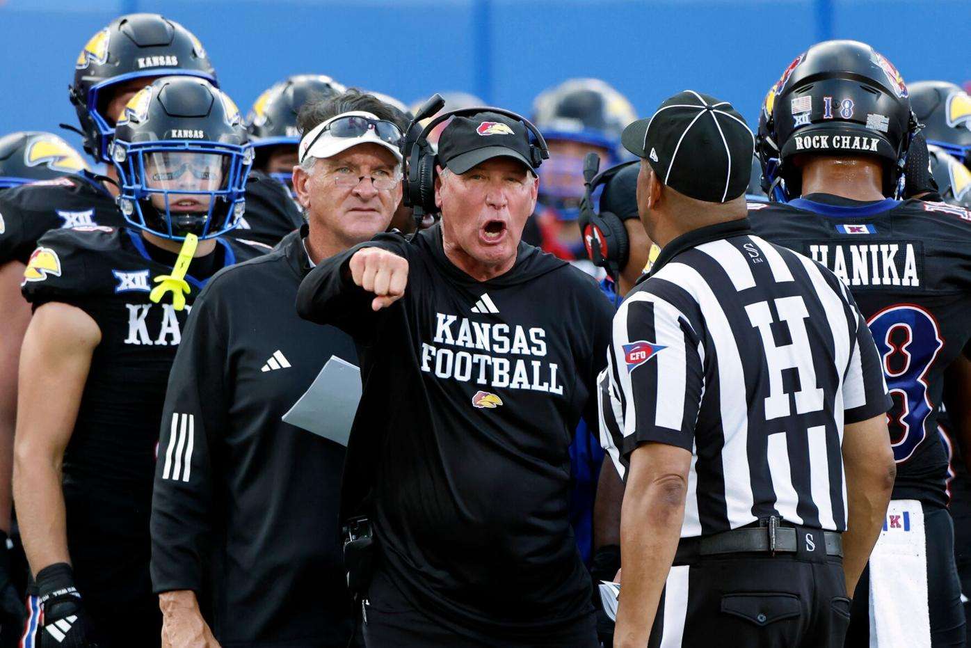 Kansas head coach Lance Leipold, center, disputes a call by an official during the first half of an NCAA collage football game against West Virginia Sept. 20, 2025, in Lawrence, Kan. (AP Photo/Colin E. Braley, File)