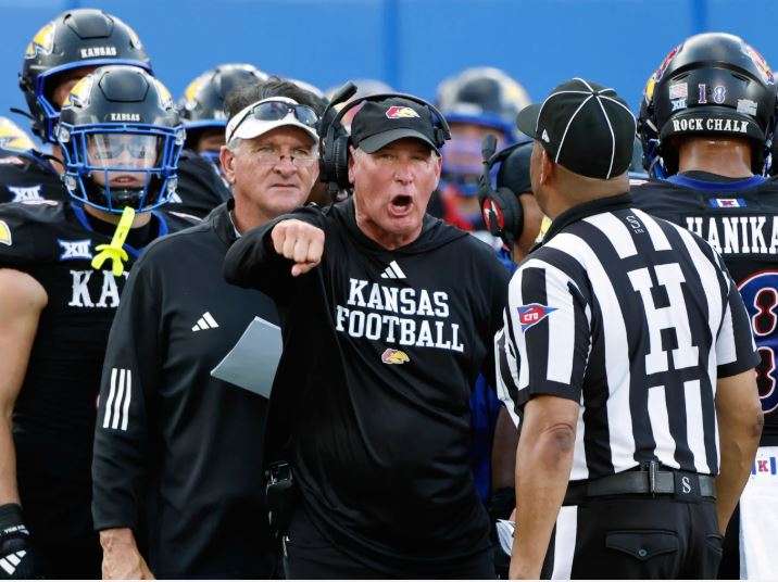 FILE - Kansas head coach Lance Leipold, center, disputes a call by an official during the first half of an NCAA collage football game against West Virginia Sept. 20, 2025, in Lawrence, Kan. (AP Photo/Colin E. Braley, File) - The Associated Press