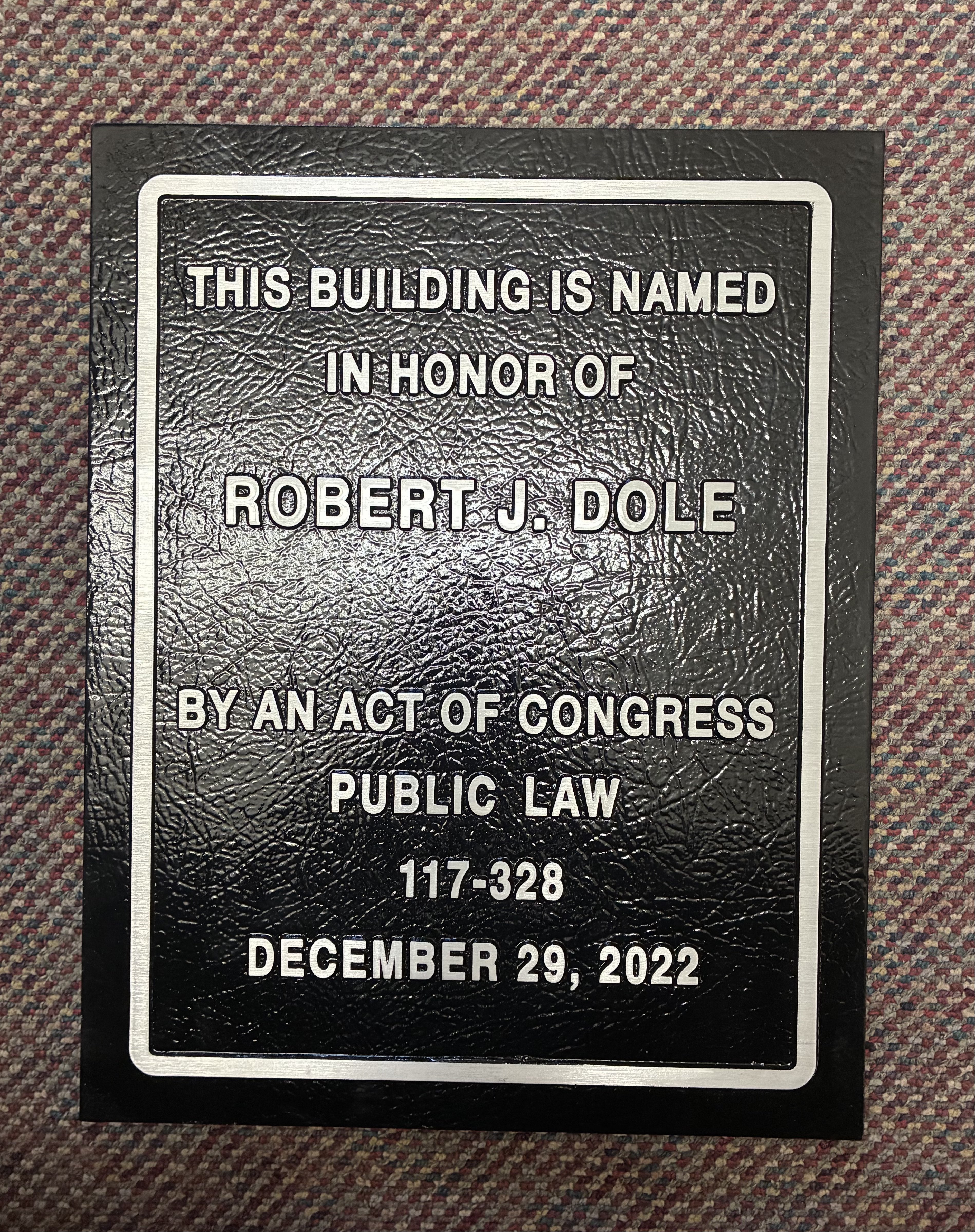 A closer view of the plaque on which is written, "This building is named in honor of Robert J. Dole."&nbsp;