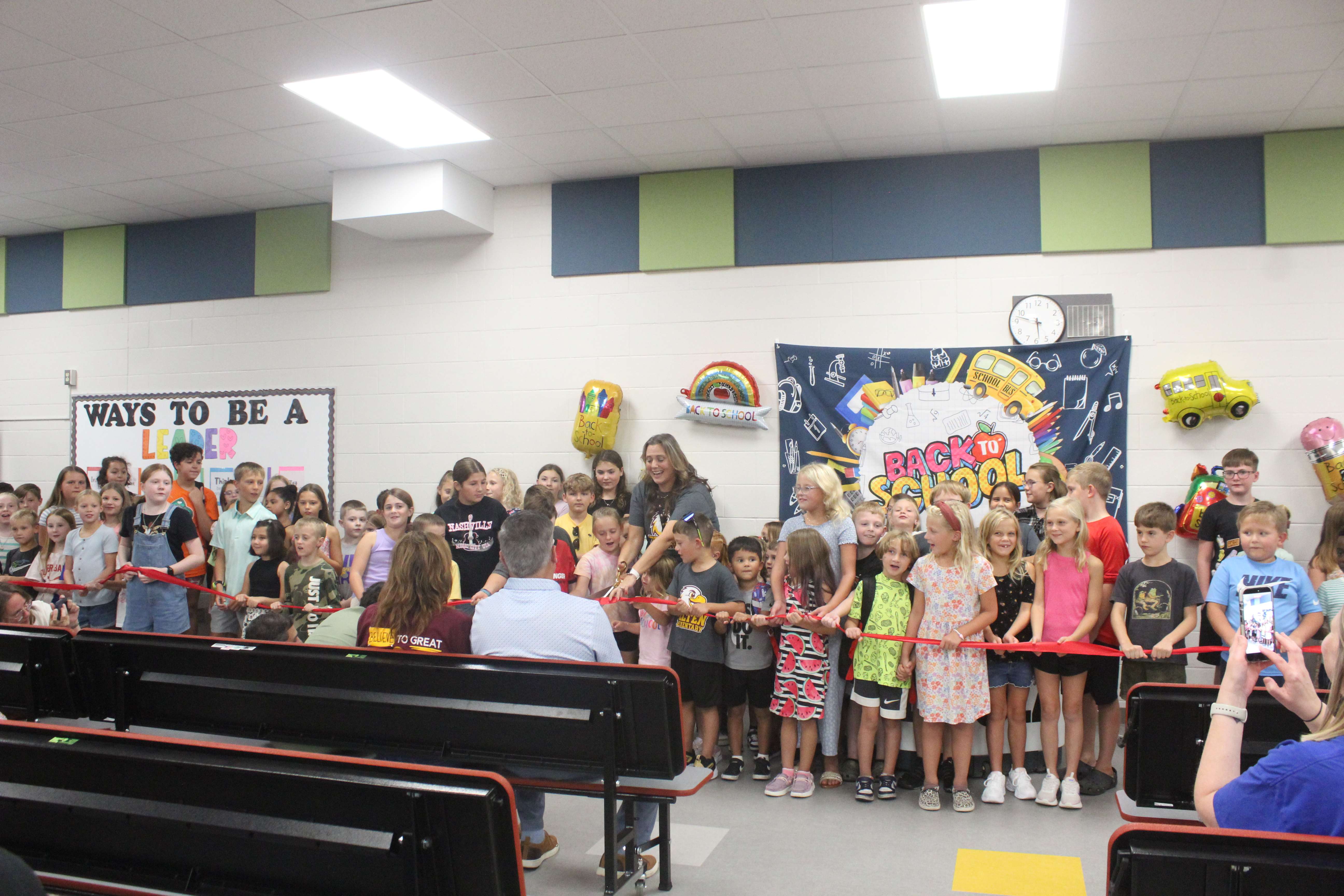 Felten Elementary School Tracy Archer, surrounded by the students, cuts the ribbon on the school's renovations. Photo by Cristina Janney/Hays Post