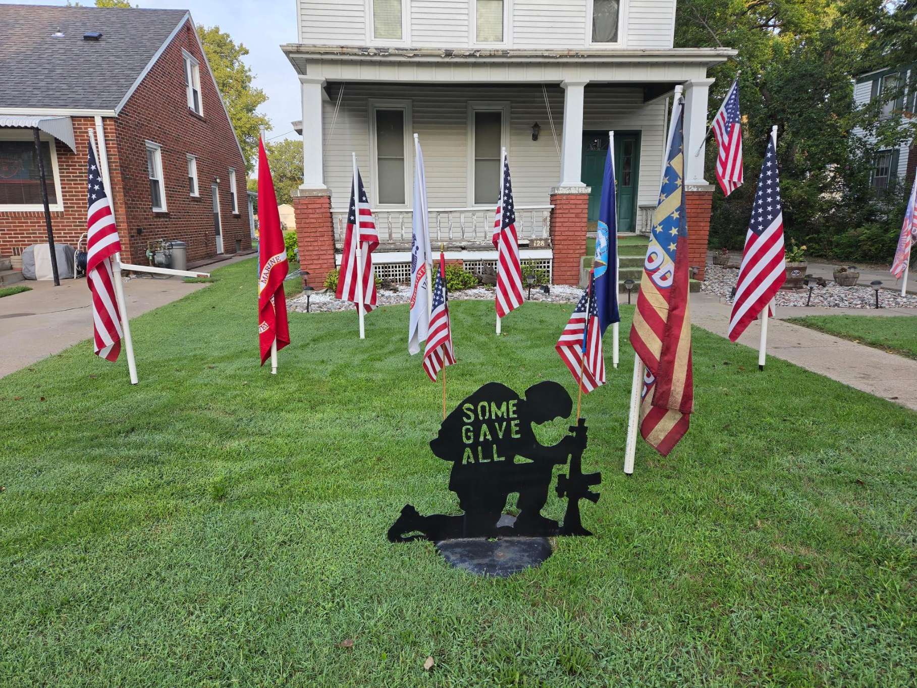 Salina resident, Kenny Cochran places flags in his front yard on S. Tenth Street to honor the 13 U.S. military servicemen and women who lost their lives in the Abbey Gate bombing on August 26, 2021 - photo by Kenny Cochran