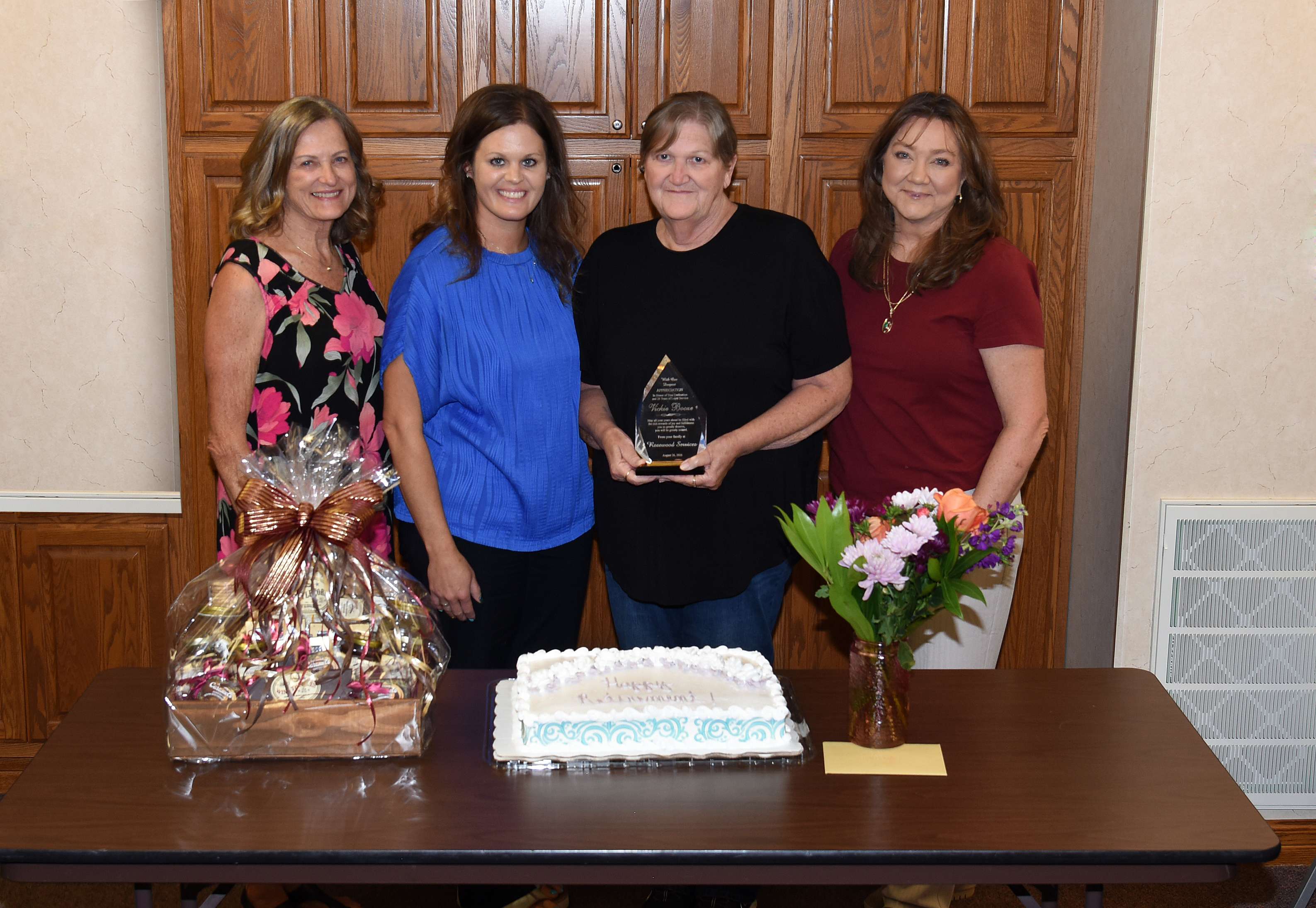 Exemplary Service – Vickie Booze (center and holding plaque) takes a photo with (left to right) Vicki Schmitt, Senior Director of Services; April Robinson, Director of Case Management; and Tammy Hammond, CEO; during her retirement reception on Aug. 26. Booze said that she values the many relationships and friendships that she has built with co-workers and clients and she will miss those daily interactions.