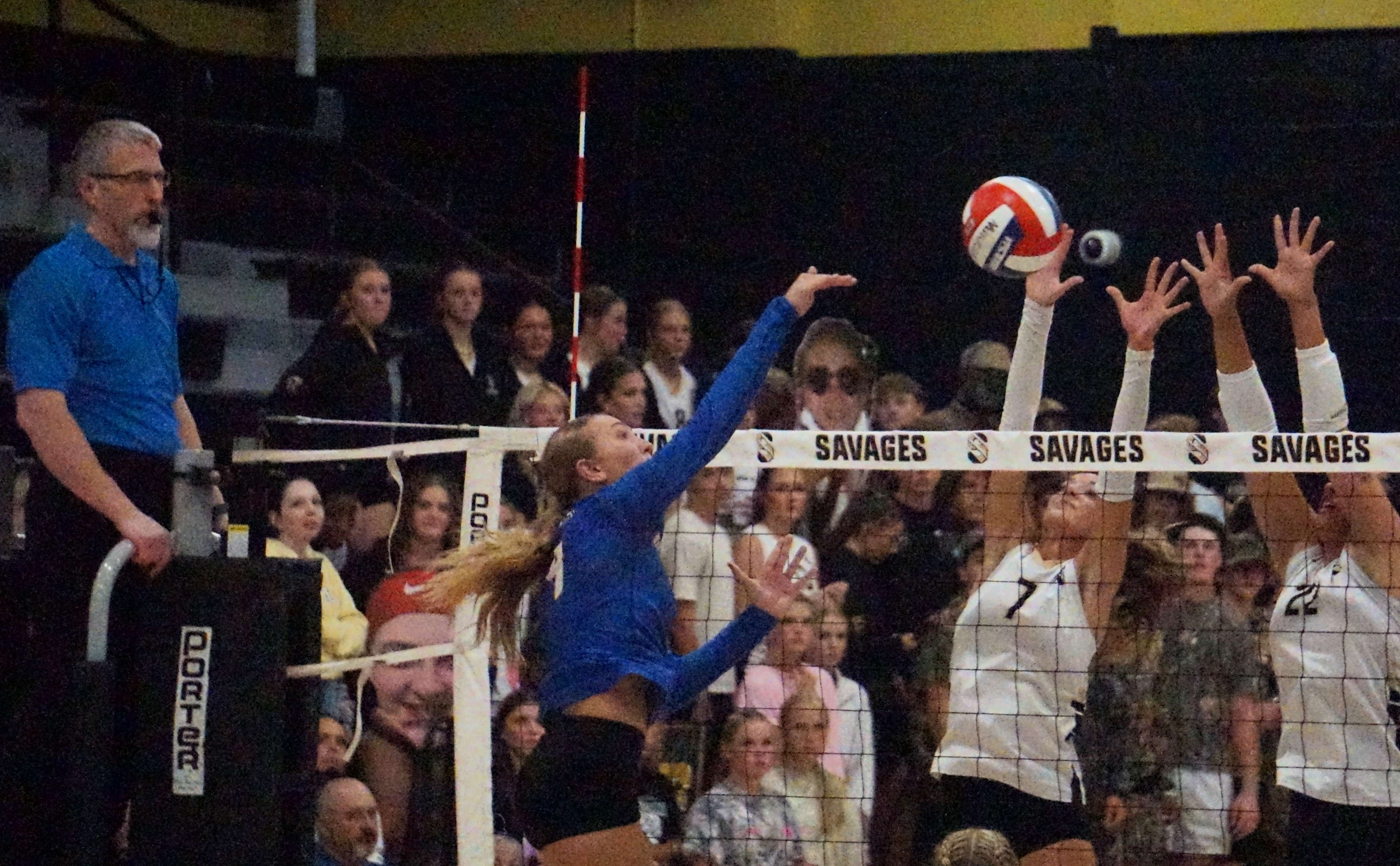 East Buchanan's Kourtney Keling (4) goes for a kill against the wall of Savannah's Ashlynn Blake (7) and Aryana Spry (22)