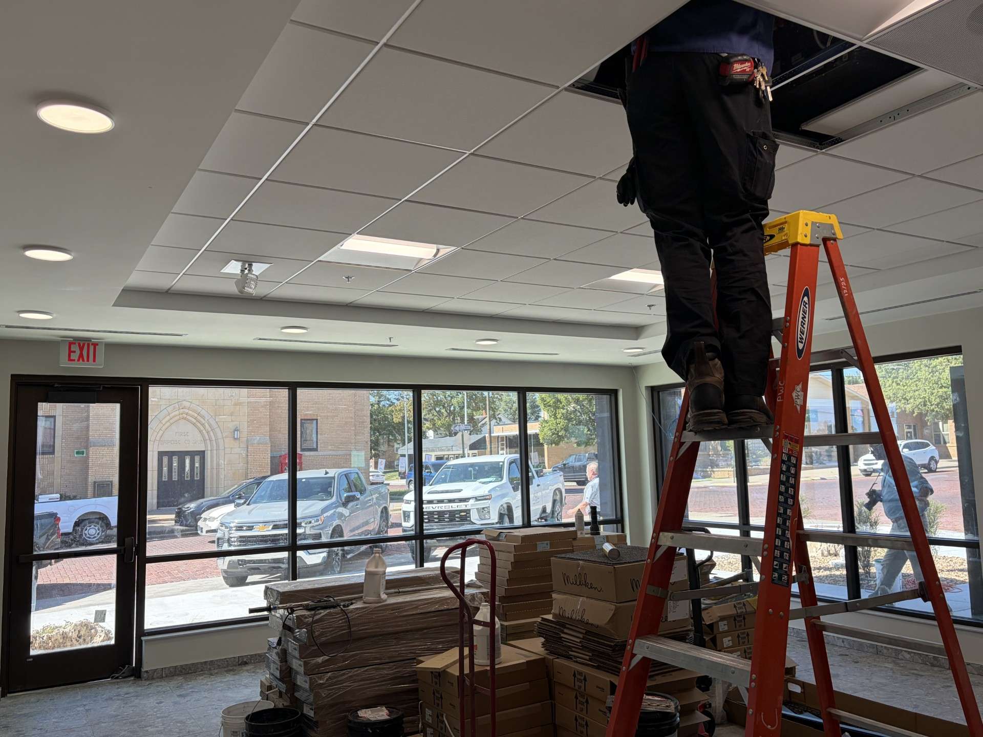 A worker maneuvers wires and cables in the ceiling of the new police department lobby. Photo by Becky Kiser/Hays Post