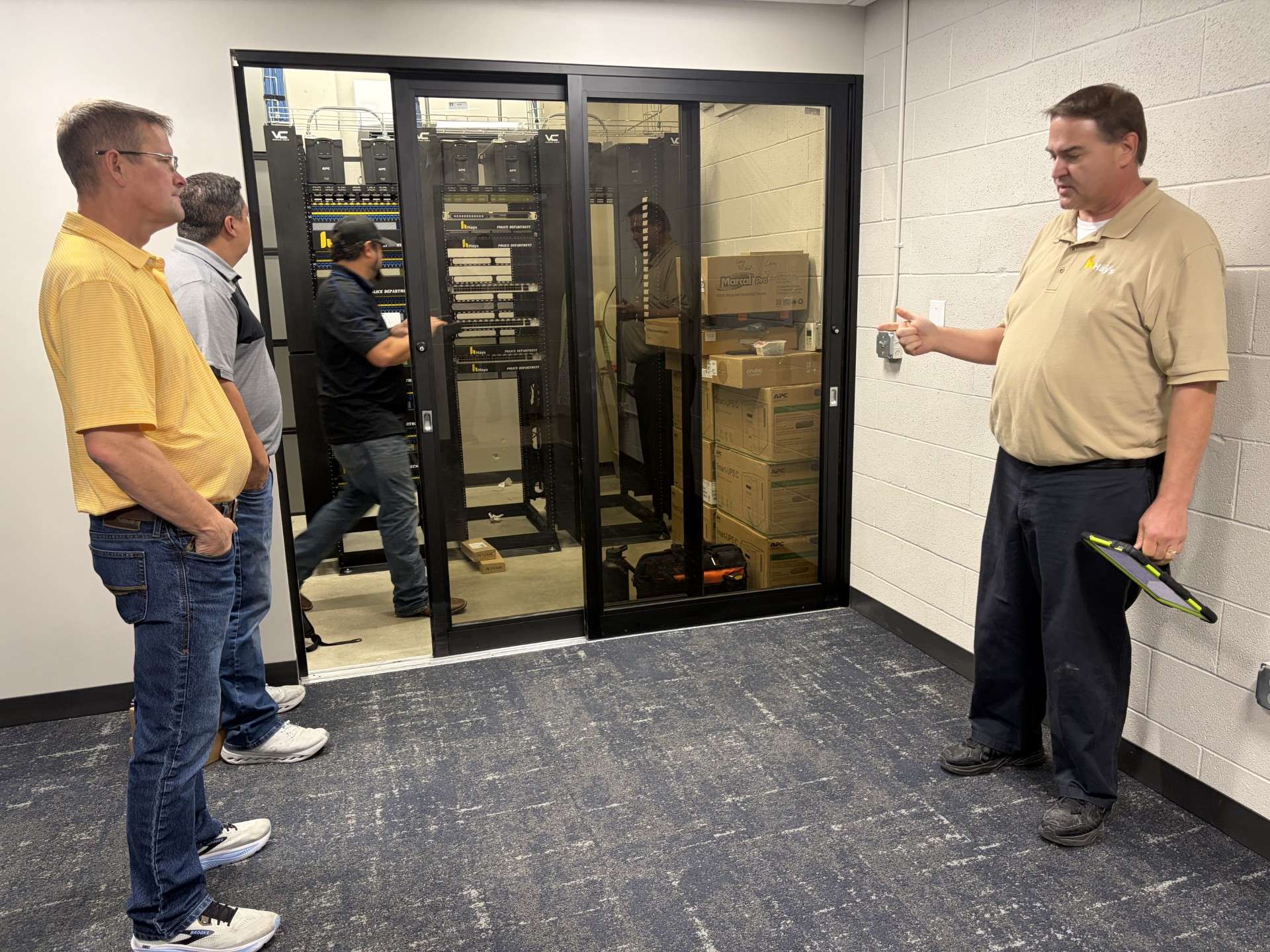 The Hays police station's computer system is being migrated away from the Ellis County system. Chad Ruder, Hays information technology director, (right) explains the process to Shaun Musil, city commissioner, and Mason Ruder, mayor.&nbsp;Photo by Becky Kiser/Hays Post