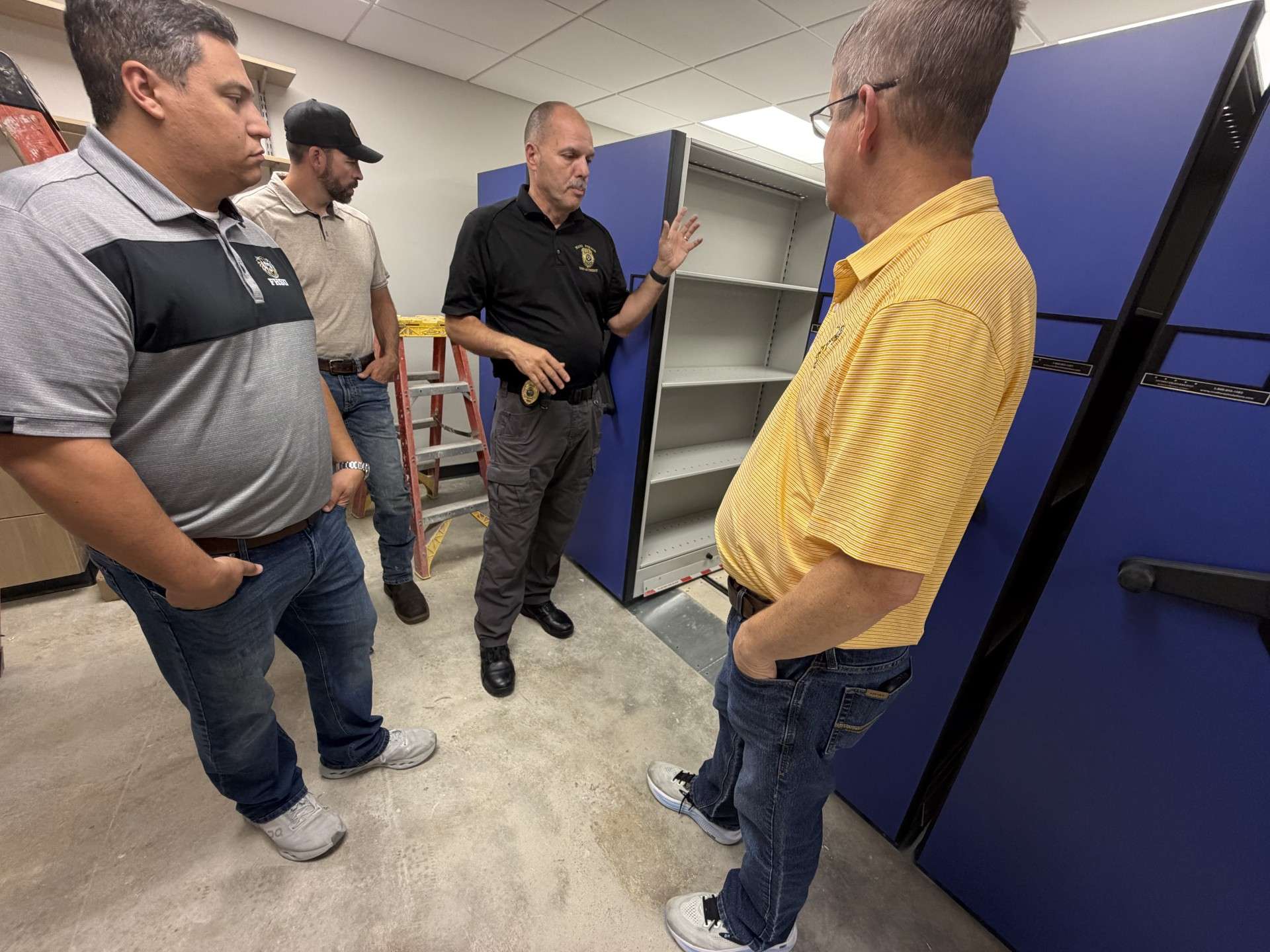 Mason Ruder, mayor; David Vilaysing, city commissioner and former Hays police officer; Don Scheibler, police chief; and Shaun Musil, city commissioner; examine the moveable evidence storage racks.&nbsp;Photo by Becky Kiser/Hays Post