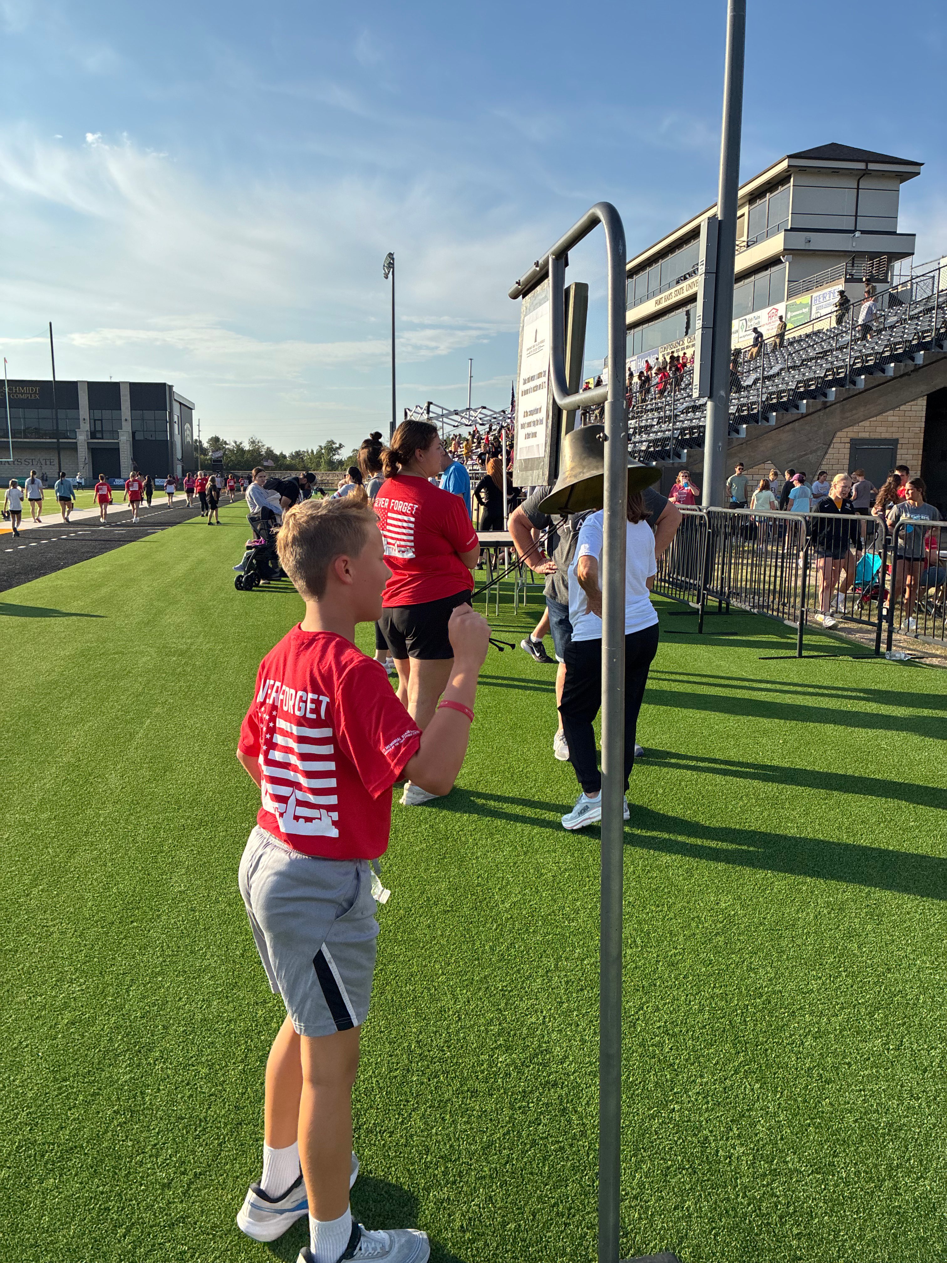A child rings the bell after completing the 9/11 Memorial Stair Climb at Lewis Field Stadium<br>